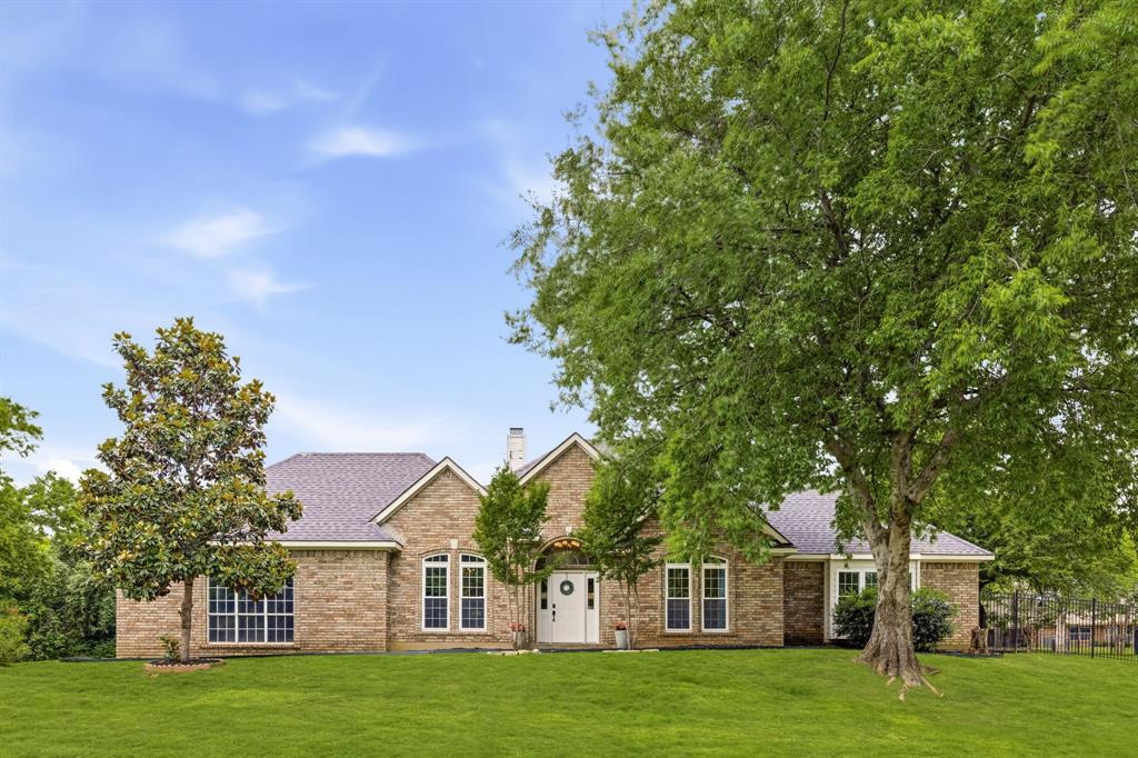 Welcome to holly lane where you will find a rare nearly 1 acre lot in the heart of DFW. Recently renovated and tucked away on a quiet and private cul de sac, 1092 Holly Lane in Lewisville offers a timeless blend of character, space, and outdoor living in a beautifully treed setting. This home spans 3,021 square feet and welcomes you with wood look tile flooring and a spacious living room centered around a cozy fireplace with a beautiful beamed ceiling, flowing seamlessly into the dining area and a well appointed kitchen featuring granite countertops, an induction cooktop, and a bright breakfast area with direct access to the backyard. The primary suite boasts a fully redesigned ensuite bath with a double shower featuring rain showerheads, dual vanities, and separate his and hers water closets two secondary bedrooms and a full bath complete the main level.A circular staircase leads upstairs to a versatile game room, exercise room and office area with access to a walk out balcony, adding even more functional space. Step outside to experience a backyard designed for entertaining and relaxation, featuring a pergola, hot tub, and plenty of room to gather under mature trees. Additional highlights include a workshop with electrical power, RV parking with hookups, and ample space for hobbies or storage. Located in the heart of Lewisville, this home offers convenient access to major highways, shopping, dining, and entertainment, as well as nearby parks and Lewisville Lake for outdoor recreation. This property combines comfort, charm, and lifestyle in a prime location.