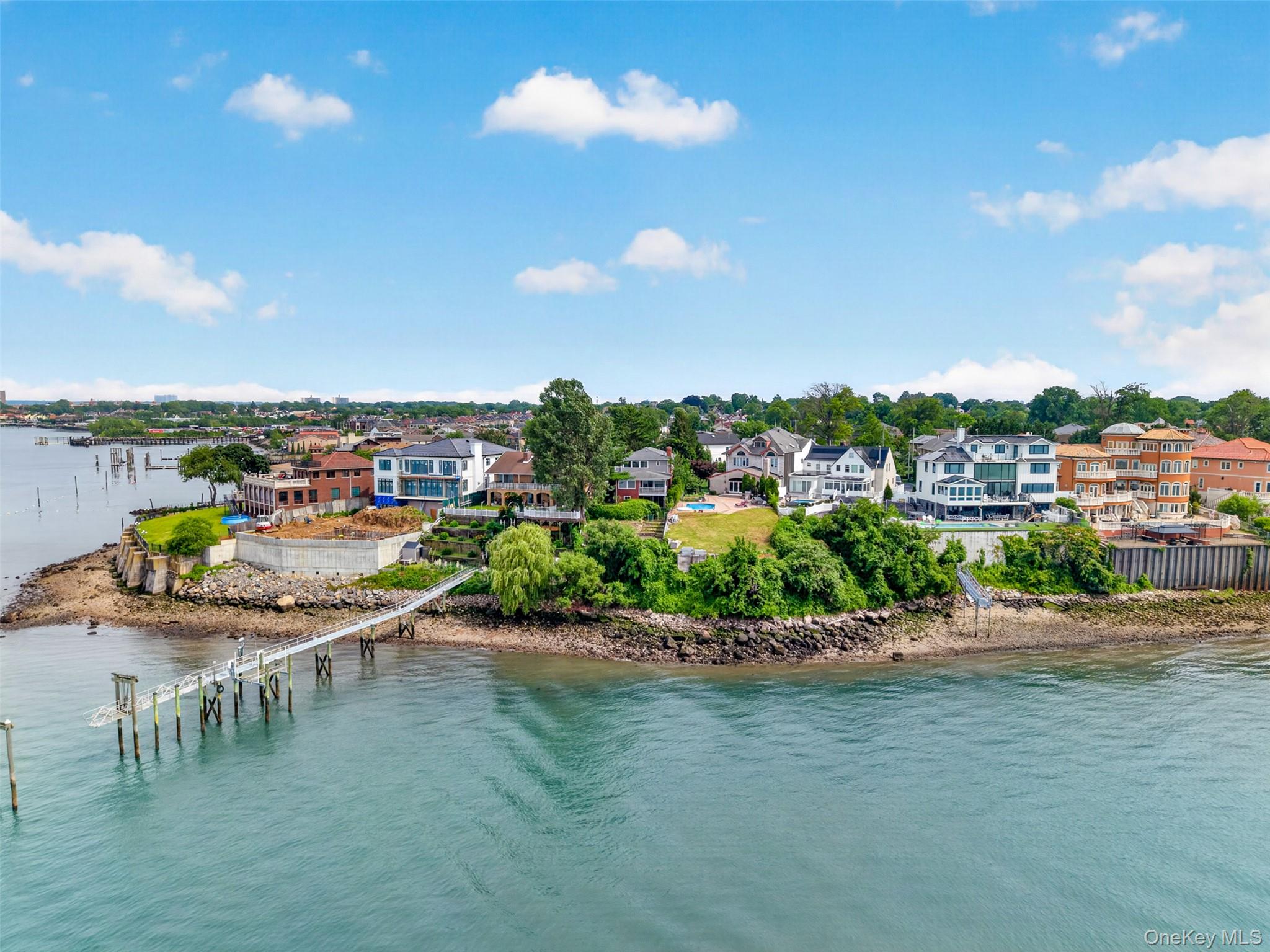 The Long Island Sound Waterfront, panoramic views of both the Whitestone and Throgs Neck Bridges and NYC, and the potential to build your own private boat dock Should Be Independently Verified. This is the kind of waterfront position that almost never comes available. This multi-level colonial is designed for someone who wants the full waterfront lifestyle without leaving the city: a gracious entry foyer leads you either up to the main living floors or down to a finished lower level with its own separate entrance, walk-out access to a covered patio and private backyard, a family room, laundry room, and 1.5 bathrooms. It is the perfect layout for a guest suite, extended family, or full entertainment level. Upstairs, the main level boasts a wood-burning masonry fireplace in the living room, an eat-in kitchen outfitted with double ovens, granite counters, and a breakfast bar, a separate dining area, a formal dining room, a flex bedroom or home office, and a half bathroom, while an oversized covered terrace delivers breathtaking waterfront views as your permanent backdrop. The top level holds the primary suite with an ensuite full bathroom and its own laundry closet, three additional bedrooms, and an additional full bathroom. With gas heat, central air, a two-car attached garage, minutes to the Whitestone Expressway, I-295, and the QM20 express bus to Midtown, this home is ready to be transformed into your dream waterfront estate.