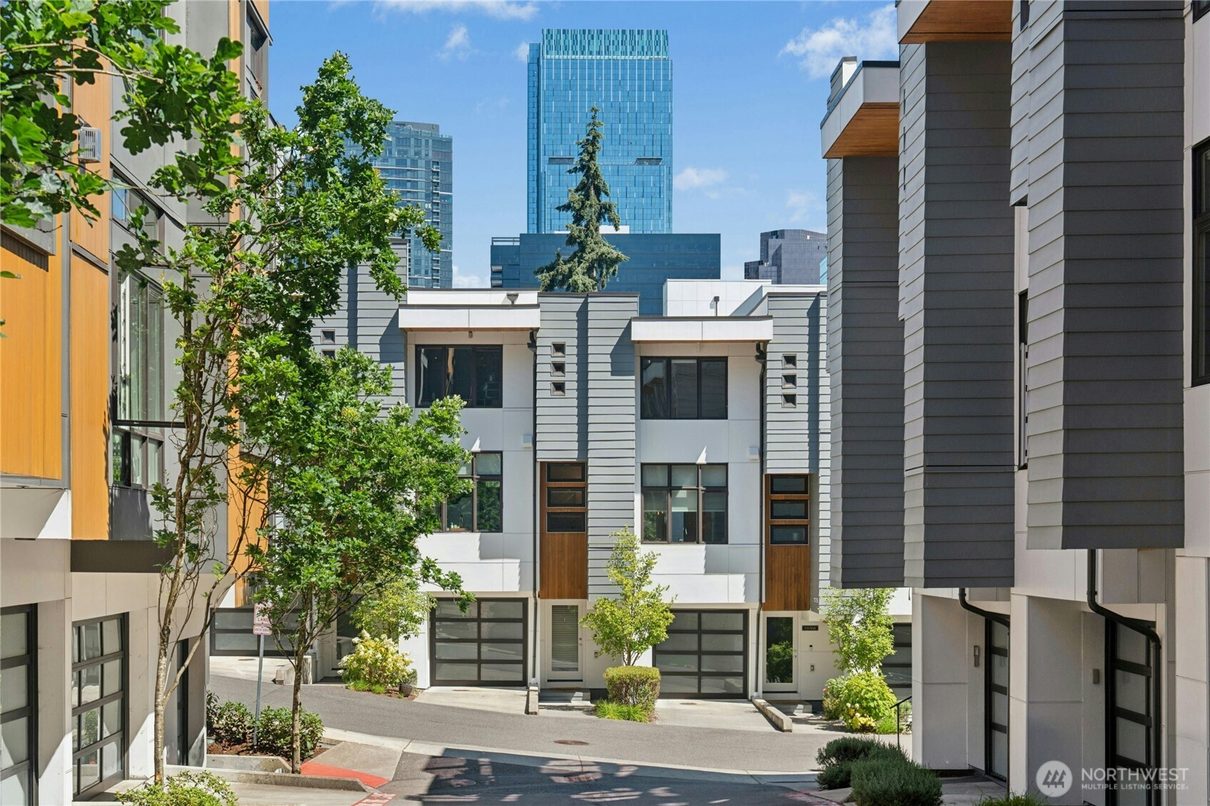 Experience modern city living in the heart of Downtown Bellevue, where elevated views, sophisticated design, and a beautifully maintained, move-in-ready interior come together. This stylish 3 bedroom, 3.25 bath residence features a light-filled open great room with oversized windows and easy access to the adjoining balcony, with city views providing a striking backdrop. The designer kitchen blends style and function with high-end appliances, sleek cabinetry, generous prep space, and an open layout that flows naturally into the dining and living areas.    Upstairs, the spacious primary suite enjoys impressive city views and features a large 5-piece bath with refined finishes and two generous closets. A second bedroom with full en suite bath and conveniently located laundry complete the upper level. Downstairs, a spacious bonus room with high ceilings opens directly to a private patio, offering flexible space for relaxing, working, media, fitness, or guests. A third bedroom and additional bath add even more versatility.    Beautifully cared for throughout, the home offers a modern architectural feel, brand-new carpet, warm finishes, and a polished sense of style. Two-car tandem garage. Exceptional Downtown Bellevue location close to premier shopping, dining, parks, entertainment, major employment centers, top-tier schools, and convenient transit—including the new light rail just blocks away.