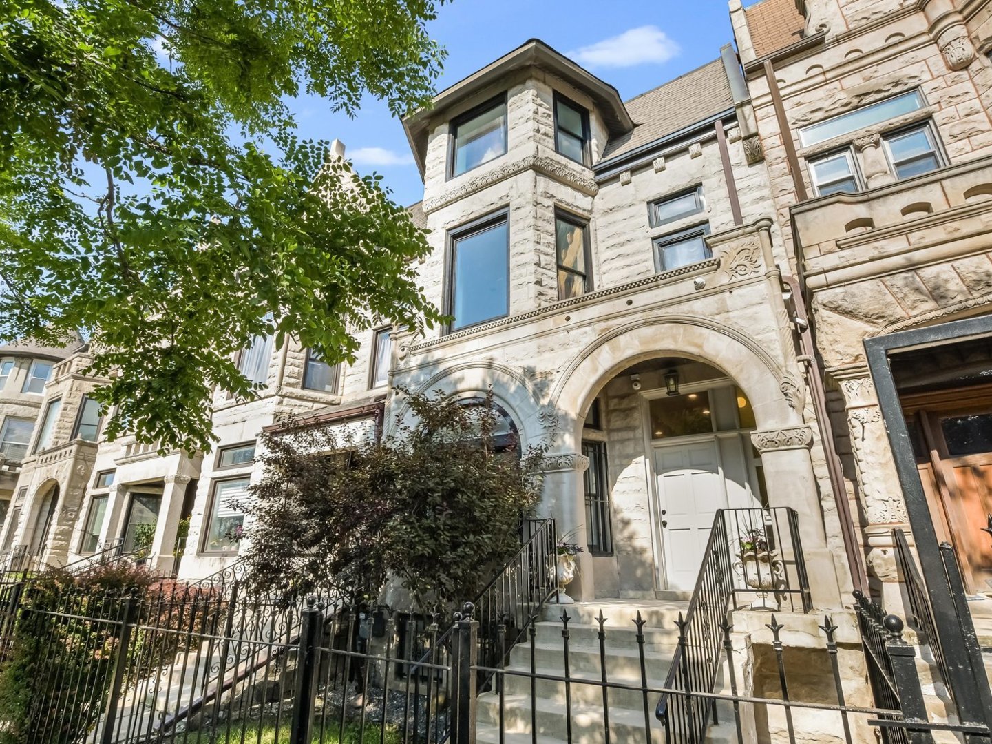 This stunning historic Greystone, located in the heart of Bronzeville on iconic King Drive, seamlessly blends timeless Chicago architecture with modern luxury. Thoughtfully renovated, the home features a spacious and airy main level designed for both everyday living and entertaining. The first floor includes a formal sitting room, dining room, living room, and a stylish kitchen-complete with quartz countertops, stainless steel appliances, and a convenient powder room. Elegant engineered white oak floors flow throughout the home, while beautiful arched windows on the east and west sides flood the space with natural light. Soaring 10-foot+ ceilings enhance the home's grand and open feel. With over 4,000 square feet, the home offers five generously sized bedrooms and four full bathrooms, plus an additional powder room. The luxurious primary suite includes a spa-like ensuite with a soaking tub. The second and third bedrooms share a well-appointed Jack and Jill bath.  Enjoy outdoor living with a deck located just off the kitchen-ideal for summer gatherings-and a detached garage featuring a party door for flexible entertaining options. Located near Mariano's, the Green Line train station, Washington Park, and easy access to the interstate, this home offers both elegance and convenience. Don't miss the opportunity to make this incredible home your own