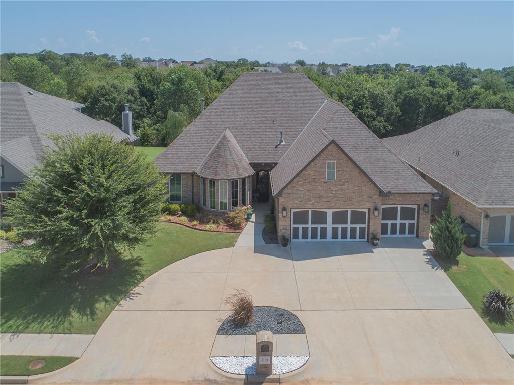 Tucked away in a sought after pocket of East Edmond, this stunning 3 bedroom, 2.5 bath home is a testament to thoughtful design and impeccable attention to detail. A welcoming semi-circle drive provides ample parking for guests. The grand entryway ushers you into a dedicated study, where beautiful bay windows flood the space with natural light. Wood look tile flooring flows seamlessly throughout the main living areas, where a centered gas fireplace and expansive, floor-to-ceiling windows create a warm and inviting atmosphere with serene views of the greenbelt. The gourmet kitchen is a chef's dream, featuring a pot filler over the gas range, stunning granite countertops, a spacious island with seating, and a walk in pantry with a brilliant built in coffee bar. The luxurious primary suite is a true escape, boasting a jetted soaker tub and a magnificent, floor-to-ceiling tiled shower with dual shower heads. The massive walk-in closet connects directly to the laundry room for ultimate convenience. The 3 car garage includes a storm shelter, while the attic provides extra storage space with a motorized lift. Outside, the extended patio and professional landscaping create a perfect oasis for entertaining or quiet evenings, all with the added privacy of no rear neighbors. As a resident, you'll also have access to the neighborhood pool and playground, making this home a must-see for anyone looking for the ultimate Edmond lifestyle.