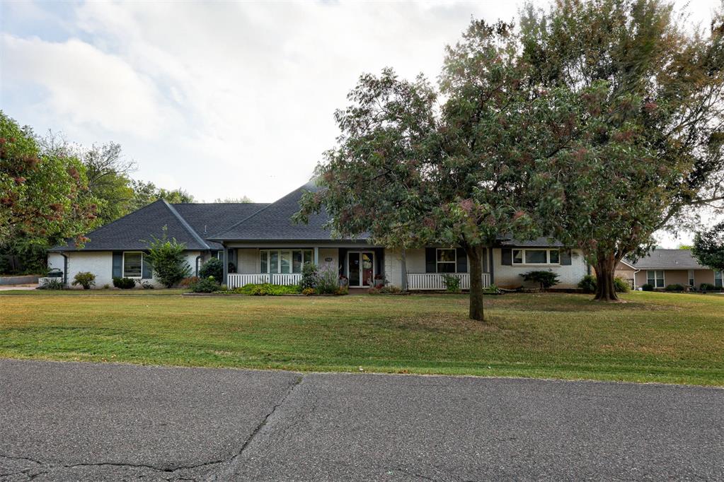 Rare find! Loaded with character, this amazing 1960s Ranch-style home is situated on a 1 acre MOL lot in the heart of Edmond! A welcoming covered porch is the perfect place to greet your guests or sit and watch the beautiful Oklahoma sunsets. Step inside for a tour of this fabulous floor plan. Just to the left of the entry is a wonderful living area with beautiful plantation shutters. Straight ahead from the entry is a "great room" style space with a living area, dining area and gorgeous remodeled kitchen. And WHAT A KITCHEN. A curved bar area offers a great place to perch and visit while the chef(s) of the family do their thing! The THIRD living area provides a peaceful view of the amazing backyard through floor to ceiling windows spanning the entire back wall. A spacious primary bedroom suite has a spa-like bathroom with two vanities, fabulous tub, large shower and THREE walk-in closets. A second spacious bedroom suite has an ensuite bathroom. A third bedroom and third full bathroom complete this amazing home. Solid flooring throughout the home, either wood or tile, no carpet! Step out back to this amazing backyard, fully fenced with a heavily wooded perimeter providing additional privacy. There is a detached 20x10 brick studio/workshop as well as two storage sheds.