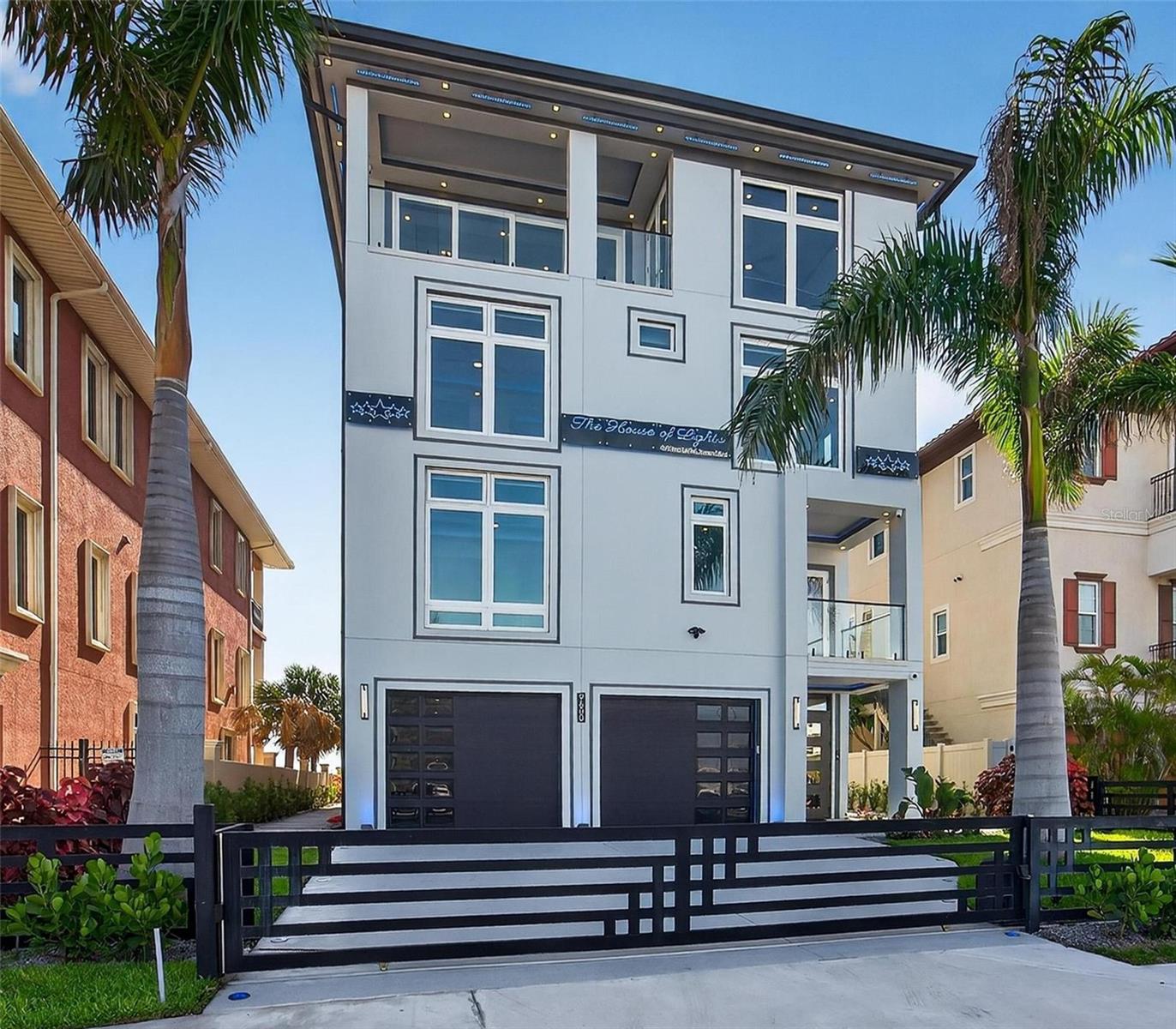 9600 Gulf Blvd | The House of Lights
5 Beds | 7 Baths | Rooftop Infinity Pool | 4-Car Garage | 5,198 Sq Ft Living | Smart Home

Florida beachfront living begins here. 9600 Gulf Blvd is a custom-built 2025 modern coastal home located in the heart of Treasure Island. This 5-bedroom, 7-bath home offers over 5,198 square feet of living space and is constructed entirely of concrete—including post-tension concrete floors on every level and a full concrete roof. Built on a deep piling foundation extending up to 45 feet into the ground, the home offers structural integrity rarely seen in residential construction. The main living floor is elevated 18 feet above sea level. Premium closed-cell and spray foam insulation ensure high efficiency, and a 32kW Generac whole-home generator adds peace of mind. Behind a private gate, the ground level includes a spacious air-conditioned garage that fits 3 or more cars and features three Tesla chargers. A covered lounge area with an outdoor shower makes it easy to rinse off after a beach walk.

Inside, the main level features a wall of glass, open living and dining areas, and a chef’s kitchen with gas appliances, double ovens, pot filler, espresso machine, wine fridge, custom backsplash, and oversized butler’s pantry with a secondary fridge. A guest suite with walk-in closet and full bath, plus a powder bath, complete this level.

The third floor includes a second living room, two additional private suites, another guest bedroom, and the spacious primary suite with dual custom closets, balcony access, and a spa-style bathroom with a large dual rain head shower.

The fourth-floor rooftop includes a stainless steel and acrylic infinity-edge pool, expansive lounge areas, a full outdoor kitchen, and a flexible indoor room perfect for a media setup, gym, or entertaining. There’s also a private office or optional sixth bedroom.

Additional features include a glass elevator, seamless fire-rated interior doors, a smart home server system, and full gas appliances. With no HOA and no CDD, this home offers rare flexibility on Florida’s Gulf Coast—just minutes from dining, shopping, and major access routes