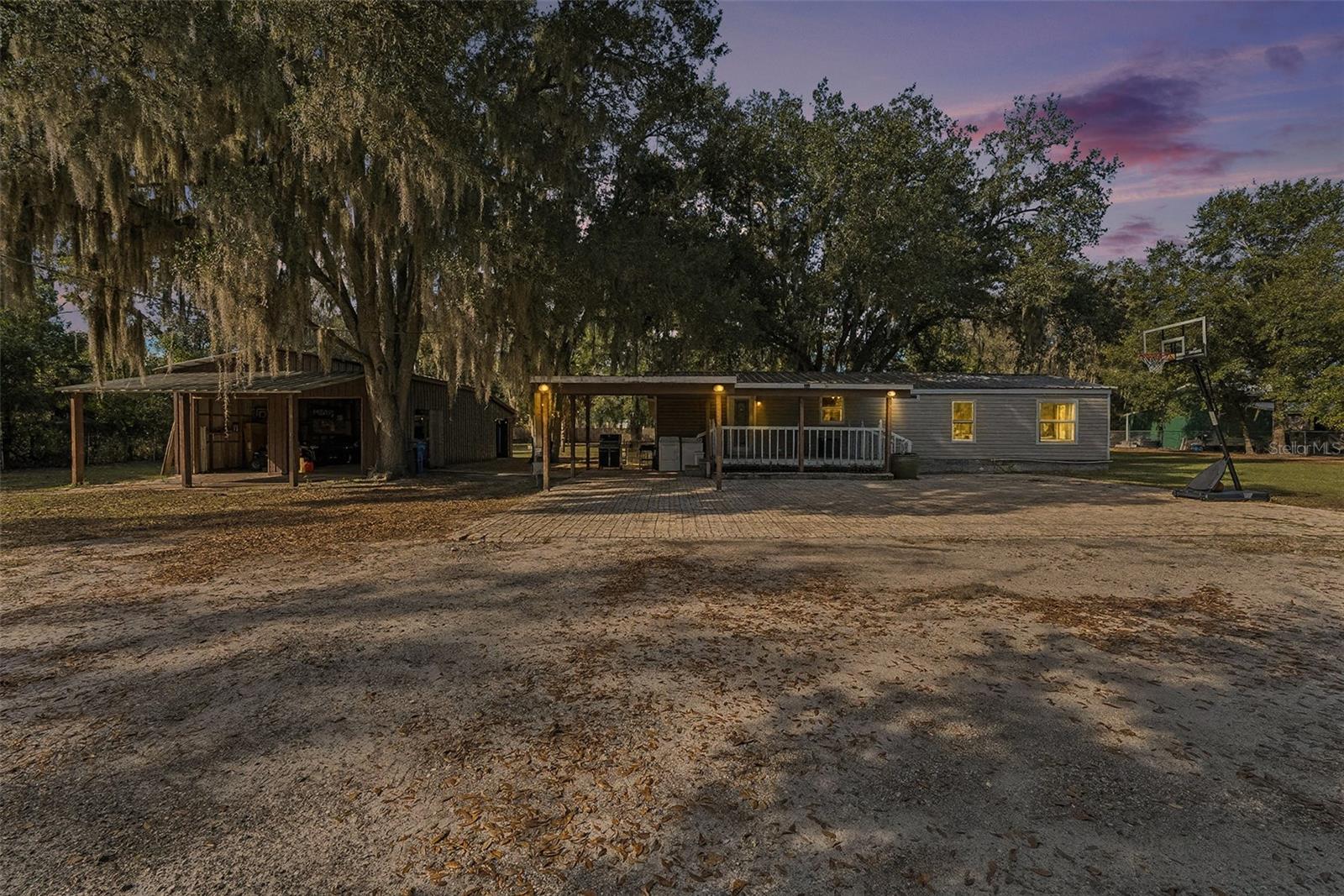 Come tour the peaceful countryside of Plant City, where privacy, space, and convenience come together on this beautifully situated 4-bedroom, 2-bath double-wide mobile home on just over an acre. There are two electrical poles that could be set up for RV's. This property is tucked away behind its own private gated entrance off a private gravel road, offering the freedom and tranquility you've been searching for — NO HOA, NO CDD, and no flood damage from last year’s storms. The heart of the property shines outdoors with expansive land ideal for gardening, animals, outdoor hobbies, or simply enjoying the open space. A major standout feature is the impressive 22'x30' detached garage, complete with an additional rear storage/garage/work room — perfect for tools, toys, projects, or business equipment. The metal roof, new 50 gallon water heater (2024), and fully remodeled primary bathroom offer comfort and peace of mind, making move-in simple. Inside you'll find a functional, spacious layout with four well-sized bedrooms plus an office room that can be made into a library or extra sitting area. Plenty of room for family or guests. Step outside to unwind, watch the sunset, or take in the quiet stillness of this peaceful rural setting. Just a short drive away, enjoy all that Plant City is known for — charming downtown streets lined with local shops and restaurants, seasonal festivals including the world-famous Florida Strawberry Festival, sprawling parks, berry farms, antique markets, and easy access to Tampa, Lakeland, and major highways. Bring your animals, your hobbies, your equipment, or simply your love for country living — this property offers the space, privacy, and lifestyle many dream of but rarely find.