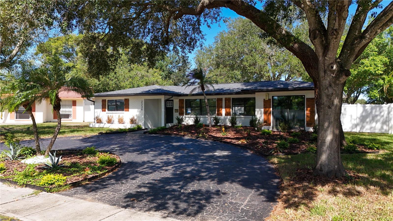 You must see this spacious 4-bedroom, 3-bathroom home with a NEW ROOF, that is thoughtfully designed with plenty of room to live, relax, and entertain! Fresh interior paint, modern fixtures and luxury vinyl plank flooring throughout give the home a clean, updated feel from the moment you step inside. The bright, open-concept living room, dining area, and oversized kitchen create the heart of the home, featuring stainless steel appliances, recessed lighting, quartz countertops, a stylish tile backsplash, abundant custom cabinetry, generous prep space, and a large center island with barstool seating. Just off the kitchen, a custom bar with a wine fridge makes hosting family and friends effortless. The private primary suite includes a walk-in closet and an en-suite bath with a beautifully tiled walk-in shower, while the additional bathrooms have been tastefully updated with modern finishes and fixtures. Step outside to the large screened lanai overlooking the oversized fenced backyard, complete with a storage shed and plenty of space to enjoy the Florida lifestyle. Located in a non-flood zone, this home is just minutes from Weedon Island Preserve, Mangrove Bay Golf Course, downtown St. Petersburg, the Gandy Bridge, Tampa, award-winning Gulf beaches, parks, shopping, dining, and entertainment. If you've been searching for a home that offers space, style and an unbeatable location, this is one you won't want to miss. So schedule your private showing today!