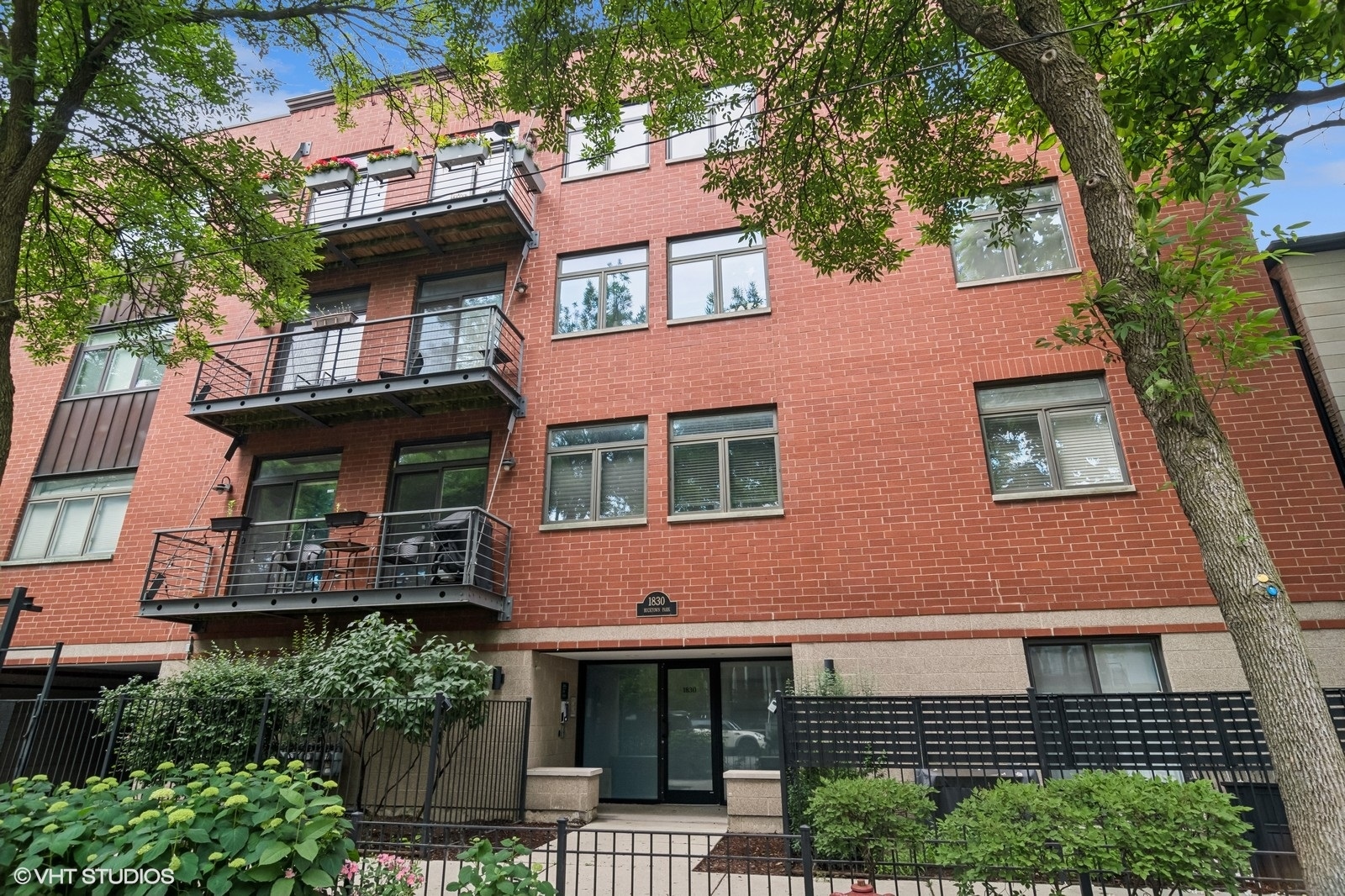 Prime Bucktown 2 bed, 2 bath in a boutique elevator building at 1830 N Winchester, Unit 207. A welcoming entryway with a coat closet opens into a bright, open-concept kitchen, dining, and living area. The living room features a gas-start wood fireplace with custom shelving and opens to a private balcony, perfect for relaxing. The modern kitchen boasts new quartz countertops, a breakfast bar, stainless steel appliances replaced two years ago, and in-unit washer/dryer. Newly installed double-paned windows, hardwood floors, wool carpeting in bedrooms, and custom drapes. The spacious primary suite includes custom closets, large master bath with double sink vanity and walk in shower. One garage parking space is included, with the option to rent additional parking-a rare find in Bucktown. The secure building has strong financial reserves and is steps from Churchill Park and The 606 trail. Enjoy nearby shopping along Damen, including Olivia's Market, Marine Layer, Aesop, Blue Mercury, and the upcoming Barnes & Noble, plus dining hotspots like Goddess & The Grocer, Le Bouchon, bartaco, Enso Sushi, Pompette, and Club Lucky. Just a short walk to Damen and Western Blue Line stations, with easy highway access via Armitage or North Avenue.