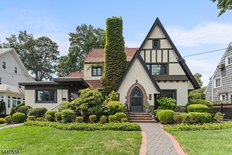 Welcome to 562-566 Irvington Avenue, a unique Tudor-style residence in Elizabeth's sought-after Westminister Hill section. Offering over 3,000 square feet of living space on an approximately 10,000 sq. ft. lot, this exceptional home combines timeless charm, modern updates, and incredible versatility. Sun-filled interiors, elegant archways, hardwood floors, and thoughtful finishes create a warm and inviting atmosphere. The renovated gourmet kitchen features granite countertops, custom cabinetry, a center island, skylights, and ample space for gathering and entertaining. Multiple living areas provide flexibility for today's lifestyle and extended living arrangements. The finished lower level includes a custom entertainment area with bar, dedicated home office, full bath, and private gym. Outside, enjoy an expansive backyard with multiple seating areas, a covered pergola lounge, professionally landscaped grounds with an underground sprinkler system, and generous open space rarely found in this location. Conveniently located near major highways, NJ Transit, Newark Liberty International Airport, shopping, dining, parks, and schools, this home offers suburban comfort with easy access to New York City and surrounding areas. A rare opportunity in one of Elizabeth's most desirable neighborhoods.