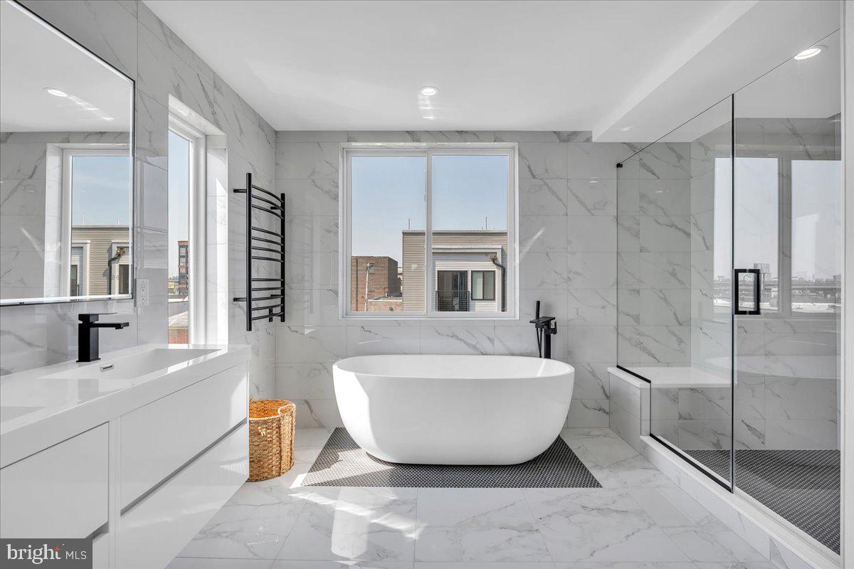 Welcome to 2620 E Hagert Street, a beautifully designed 3 bed, 3 bath townhome with garage parking located in the vibrant Fishtown neighborhood. This modern corner unit offers sunlight drenched & thoughtfully crafted living space, combining clean, contemporary design with comfort and functionality —and it comes with the added benefit of a 10-year tax abatement, offering long-term savings for the new owner. Step inside to discover an airy open layout featuring high ceilings, wide-plank hardwood floors, and oversized windows that flood the home with natural light. The main level features a stunning custom kitchen with quartz countertops, a large island, sleek cabinetry, and stainless steel appliances. While the kitchen and living room are separated by two levels, the design maintains an open, connected feel, giving each space a distinct identity without sacrificing flow—perfect for entertaining or relaxing. Upstairs, the luxurious primary suite offers a peaceful retreat with a walk-in closet and spa-like ensuite bathroom with a double vanity, floating tub, and glass-enclosed shower. Two additional bedrooms provide ample space for guests, home offices, or growing families. The fully finished basement adds even more versatility, perfect for a media room, fitness area, or creative workspace. One of the standout features of this home is the expansive rooftop deck, offering unobstructed views of the Philadelphia skyline and Ben Franklin Bridge—an ideal spot for entertaining. An attached garage adds rare convenience in the city, providing secure parking and additional storage. Located on a quiet residential block just steps from the heart of Fishtown, this home offers easy access to neighborhood favorites like Reanimator Coffee, Green Eggs Café, Loco Pez, and the new Anna & Bel Hotel. With close proximity to I-95 and the L train, the location of 2618 E Hagert makes for an easy commute to anywhere in the city and surrounding areas. This is modern city living at its best—schedule your private tour today.