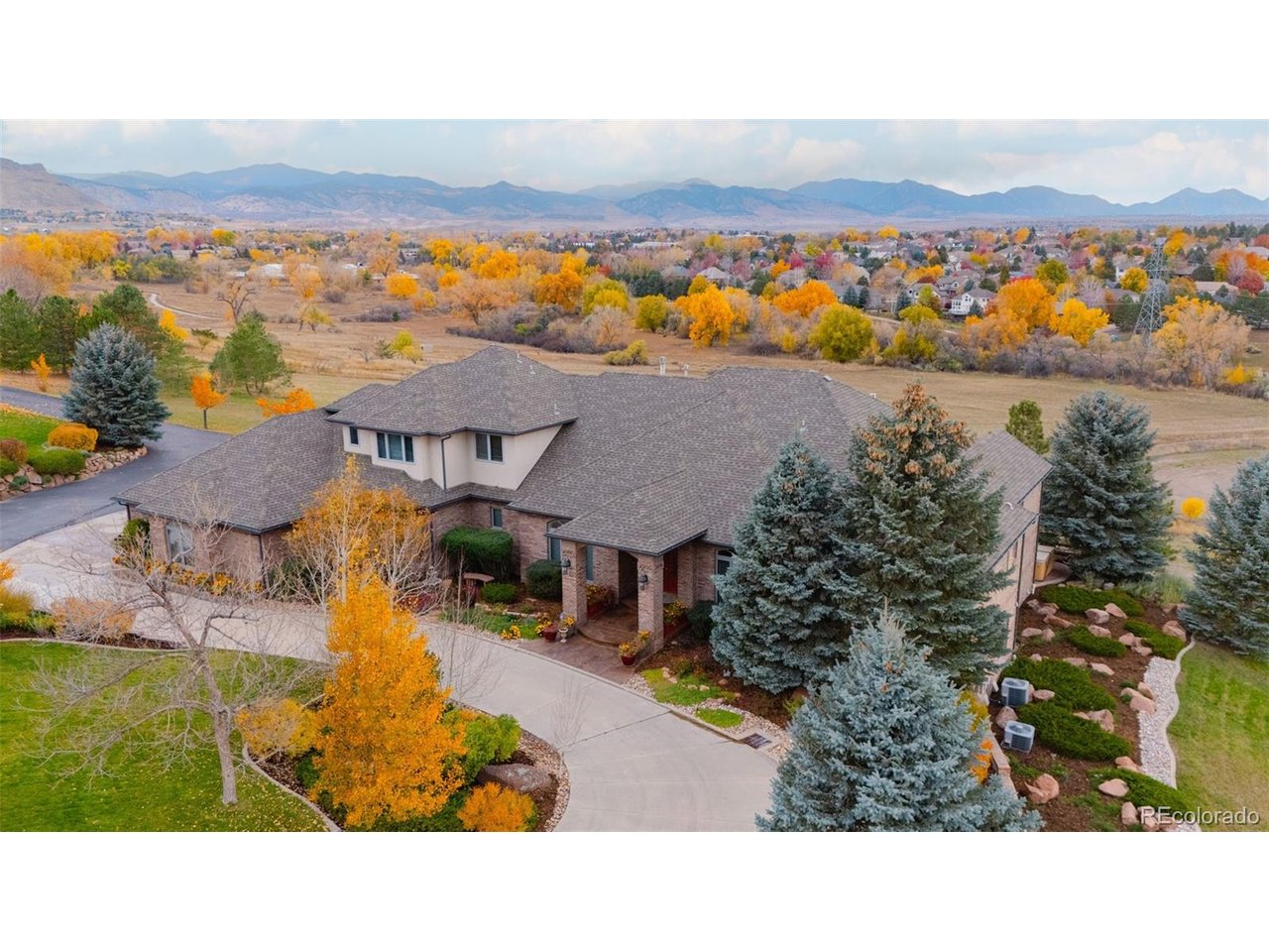 Full video, 3D Tour, and all images at 5495eldridgestreet.com. Iconic, peaceful estate expanding over 5 private acres with endless mountain views, overlooking a wooded valley. Horses are allowed, with access to adjacent open space for riding.  Enjoy your daily interactions with wildlife in a setting usually only found deep in the mountains, all conveniently located near daily conveniences.  Custom craftsmanship and modern luxuries live in harmony inside. The kitchen offers luxurious form and function - Blue Star six-burner range with griddle and Viking Pro hood with warming lights anchor the space, complemented by a Sub-Zero refrigerator, Miele dishwasher, and extensive live edge granite countertops. The main living space is adorned by custom bubinga and koa wood built-ins. Sonos, zoned surround sound and subtle crown lighting set the tone for hosting. All bedrooms host a full en-suite bath and walk-in closets. The study is remarkable, having been featured in design publications - bookmatched flamed mahogany with padded silk walls, copper ceiling, cherry flooring, custom cast hardware and nailhead trim exemplify the level of detail. Outdoor living is equally compelling. From the elevated deck to the patio and hot tub, each space frames breathtaking views. The property's private ball field adds a rare recreational touch. The second level is ideal for multi-generation living or nanny quarters with a living room, bedroom with en-suite bath and is setup to install a kitchenette.  Finished walkout basement with exercise space, bonus/craft room, bedroom with en-suite, media space and wet bar with Viking wine fridge, Miele built-in espresso machine, custom cherry and curly maple woodwork. Two gated entries, circle drive, lush landscape and acreage. Ideal for hobbyists with 4-car garage plus 2,000-square-foot heated outbuilding. This is a sanctuary that celebrates fine living in a beautiful natural setting with convenient access to Golden, Arvada and Denver.