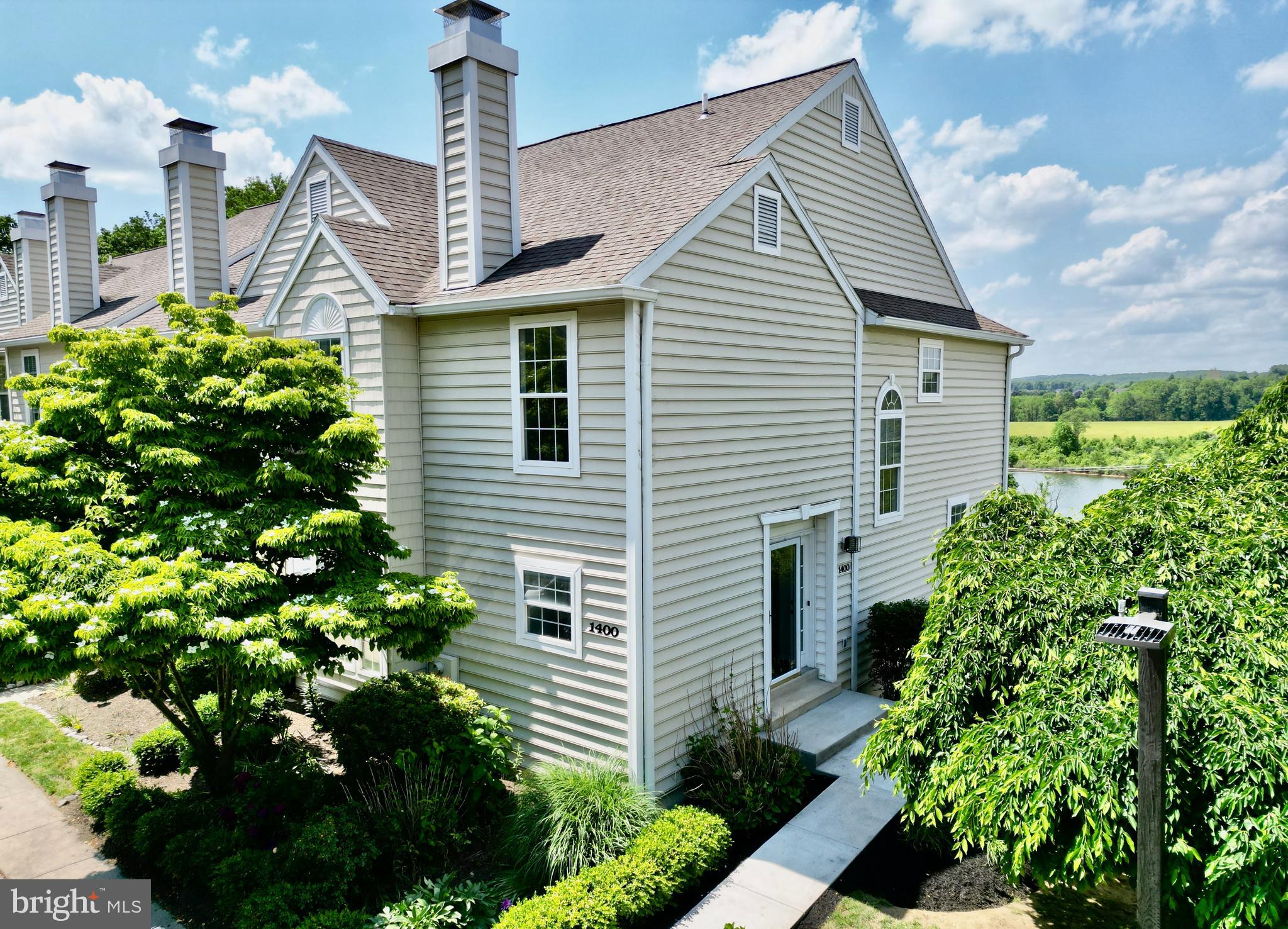 Set in Marsh Harbour, a CAI Gold Star Community in Downingtown, 1400 Harbour Ridge Ln offers the lake-view setting buyers look for, with the added benefit of an end-unit layout and additional square footage. This 3-bedroom, 2.5-bath home features nearly 1,800 square feet of inviting living space filled with natural light, including a spacious main level with a large living and dining combination designed for easy everyday use and entertaining. The kitchen opens through sliders to the upper deck, creating an outdoor extension of the home where lake views and sunsets become part of the daily backdrop. Upstairs, the primary bedroom includes an oversized ensuite bath, while two additional bedrooms, another full bath, and second-floor laundry add practical comfort. Four fireplaces bring warmth and character throughout the home, with fireplaces on the main level, in the primary suite, and in the finished lower level. The walkout lower level features brand-new LVP flooring and opens to a lower patio with more lake views. Marsh Harbour amenities include a rentable clubhouse with full kitchen, 24/7 fitness center, saltwater pool, baby pool, hot tub, tennis court, four pickleball courts, multi-purpose court, tot lot, and community library. Walking paths connect the community to nearby Marsh Creek State Park, known for its 525-acre lake, picnic areas, trails, and seasonal rentals for sailboats, paddle boards, canoes, kayaks, and row boats. Close to shopping, dining, parks, and major roadways, this home brings together lake-view living, thoughtful space, and convenient access to Downingtown-area amenities.