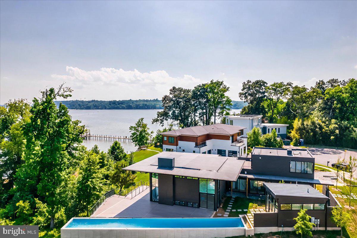 AUCTION: Bidder registration deadline: 16 September.  Starting bids expected between $2.5M-$3.5M.On the banks of the Potomac minutes from Old Town Alexandria and Washington, D.C., this brand-new modern residence rises on circa-1777 legacy land developed for the first time. Neighboring George Washington's Mount Vernon, the estate offers 80 feet of shoreline and 315 feet of dockage with a new boat lift, ideal for arrival by yacht or the scenic George Washington Memorial Parkway. A cantilevered 75-foot lap pool stretches toward the river beside a pool house with an entertainment bar and private studio. Evenings unfold on the wraparound veranda by the fire pit or atop the rooftop deck with 360-degree views. Kimmel Studio Architects used steel-beam construction and 18-foot glass curtain walls framing the Potomac's dramatic tides, built for the serious mariner and soul-searcher alike.