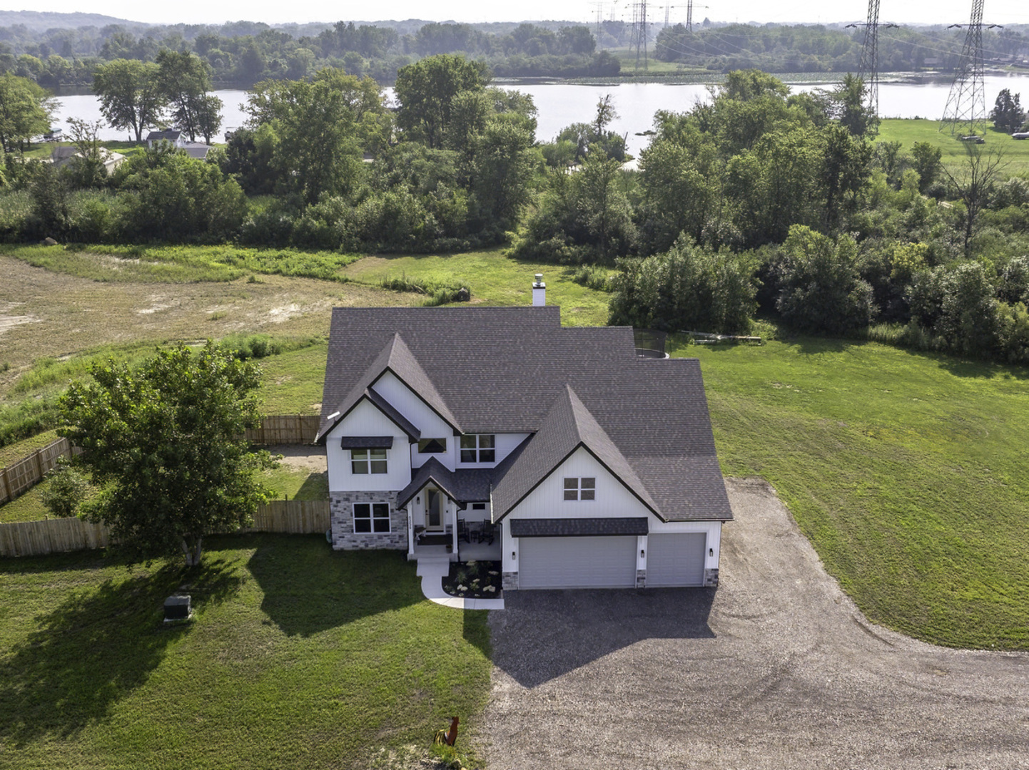 RARE 5 ACRE Navigable WATERFRONT OASIS with Private Marina and BOAT DOCK. This custom-built 5-BEDROOM, 4.5-bathroom home sits on over 5 acres in the sought-after COAL CITY SCHOOL District. The open-concept design features SOARING CEILINGS, oversized windows, and a dramatic floor-to-ceiling stone fireplace as the centerpiece of the living space.    The GOURMET kitchen is a showstopper with crisp white cabinetry, a large QUARTZ island with seating for six, built-in double oven, stainless steel appliances, massive built-in refrigerator and freezer, and a 5'x6' WALK-IN PANTRY all flowing seamlessly into the dinette and living room.   Each of the 5  bedrooms includes a WALK-IN CLOSET. 3 bedrooms have their own private baths, and 2 bedrooms share a Jack & Jill bath. A main floor bedroom and laundry add convenience. Every bath is beautifully tiled.    The OVERSIZED 4+ CAR GARAGE (32x28 plus 13x28) easily accommodates full-size trucks, equipment, and recreational toys, even the tractor fits with ease. The FULL BASEMENT features rough-in plumbing and 2 huge egress windows for future finishing. FENCED area for pets, natural gas, dual-zone HVAC, and energy-efficient systems provide comfort and practicality.    Step outside to your private oasis with a COVERED FRONT PORCH, huge COVERED CONCRETE PATIO and upper BACK DECK, perfect for enjoying breathtaking river views and sparkling sunrises. This property also includes half-ownership in an additional 4.3-acre nature preserve and riverfront parcel with a cove/marina and gazebo. Room to add a pole building.    Located at the head of the Illinois River, this home offers unmatched boating, fishing, skiing, and tubing right from your backyard. A rare opportunity to own a luxury WATERFRONT retreat with privacy, recreation, and stunning natural beauty.  *Floodplain concerns? Not here! Seller is completing FEMA's LOMA process to officially remove the home from the floodplain.