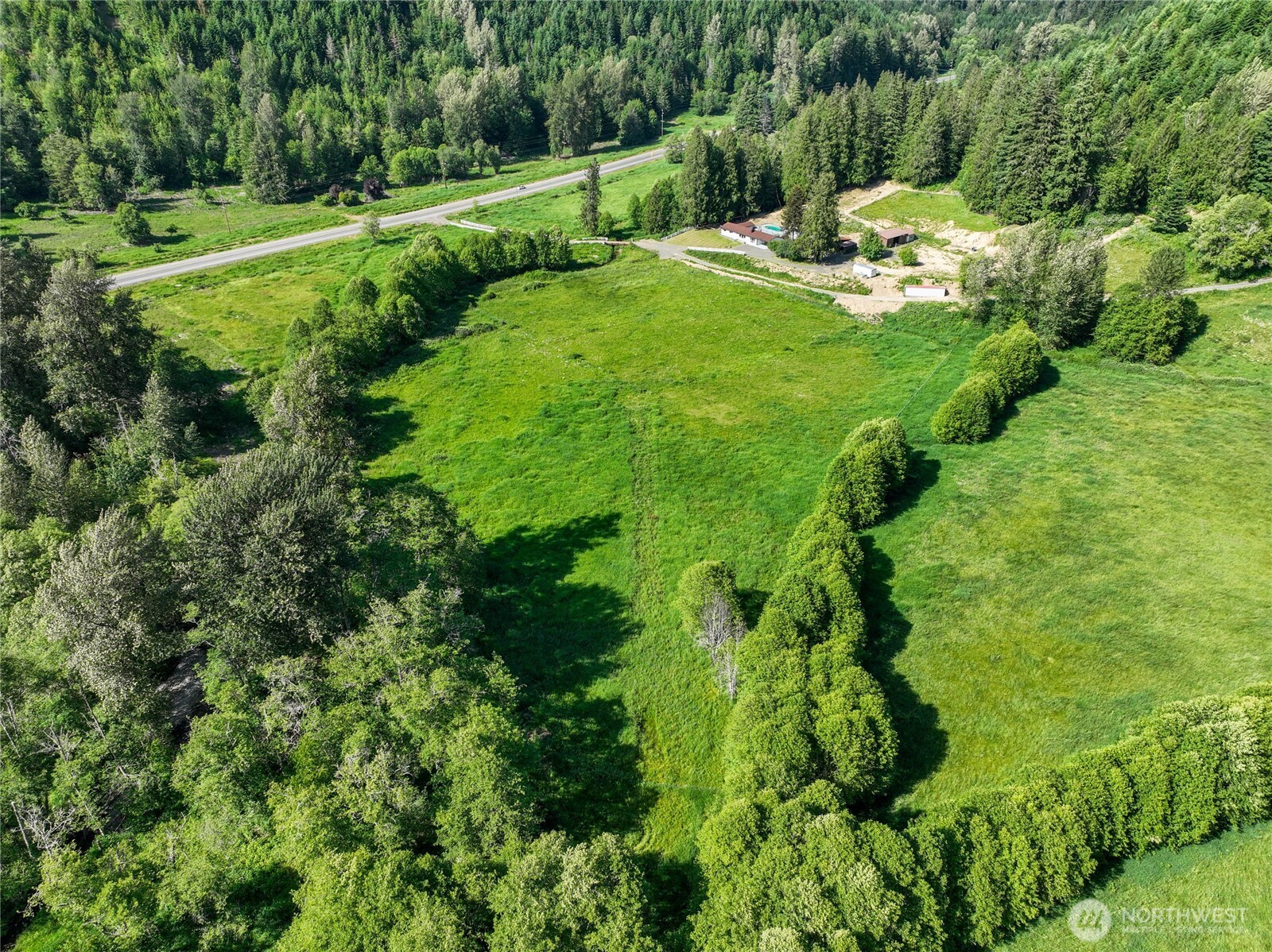 Nestled among rolling pastures, mature timber, and newly planted Douglas Fir, this 20+ acre legacy property offers the perfect blend of country living, recreation, and self-sufficiency. Wander the network of trails on foot, horseback, or ATV, then cool off in the in-ground pool or relax along the year-round creek that meanders through the property, creating shady retreats for entertaining and outdoor enjoyment. The ground feature fenced pastures, apple and cherry trees, a stable, large chicken coop, shop, and additional covered parking for equipment, hobbies, or farm use. The charming Lindal Cedar Home is designed for flexibility and comfort, featuring a sitting room off the primary suite ideal for a home office, reading nook, or hobby space, plus a bonus room on the opposite side of the home. Though the home has had upgrades, the original charm has been left to enjoy, including slate and hardwood flooring, a wood stove for additional heat and exposed beams in the living room. Whether you're seeking a hobby farm, equestrian property, recreational retreat, or multigenerational homestead, this exceptional acreage offers room to grow, explore, and create lasting memories. Also, to note, is that the land can be divided into 10-acre parcels, giving the opportunity to split and sell or to develop further. RV Pad has power and so does the field across the driveway for easy hotwire hookup. Take your time to walk this property, it is well worth it!