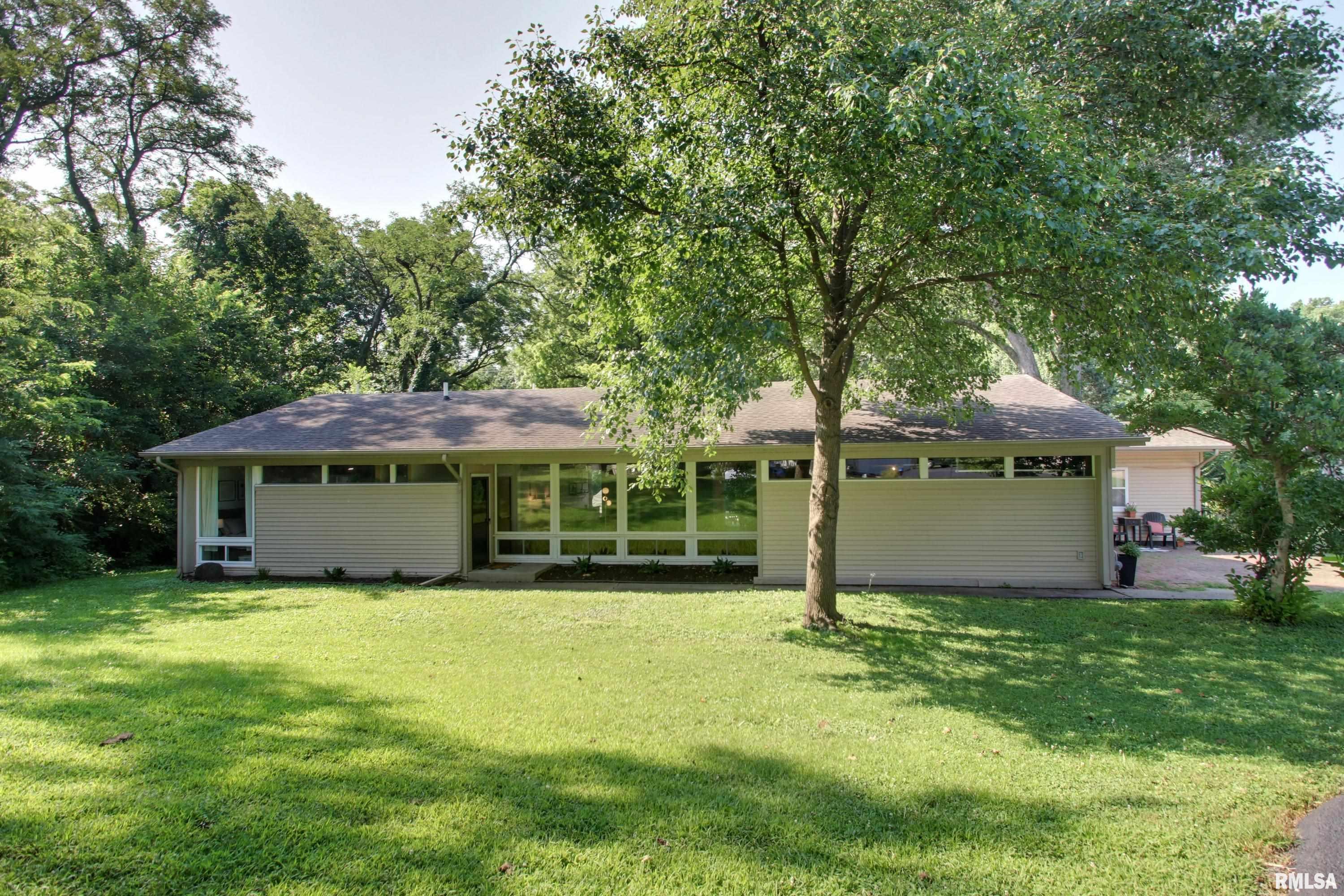 Welcome to 3036 Lincoln Hill SE Street in Quincy, IL—a beautifully updated 4-bedroom, 2-bath midcentury modern home offering 1,862 square feet of thoughtfully designed living space. Designed by Quincy architect John Benya and tucked away at the end of a quiet street, this private retreat backs to a peaceful creek and is surrounded by mature greenery, creating a setting with amble natural light throughout the home.  Blending timeless midcentury character with stylish modern updates, this home features a stunning kitchen complete with quartz countertops, custom cabinetry, and stainless-steel appliances. Both full bathrooms have been tastefully renovated with contemporary fixtures and finishes. At the heart of the home is a striking double-sided fireplace that serves as a beautiful focal point between the living room and dining area, creating warmth, character, and an inviting atmosphere for both everyday living and entertaining. Signature midcentury architecture and expansive windows seamlessly connect the indoors with the natural beauty outside.  A two-car attached garage provides added convenience, while the exceptional location at the end of the street offers privacy that is hard to find. With a picturesque creek just beyond the backyard and a setting surrounded by nature, this home truly feels like a peaceful retreat. Don't miss this incredible opportunity to own a piece of midcentury magic that checks all the boxes. Schedule your private showing today!