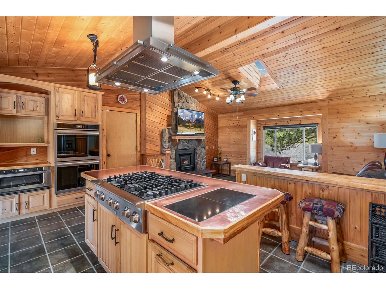 Experience the unmatched lifestyle of Carter Lake living in this custom-built ranch tucked into a private 1.9-acre setting with breathtaking foothill, valley, and city light views. Surrounded by outdoor recreation including boating, fishing, hiking, paddle-boarding, and horseback riding, this property offers true Colorado living at its finest. Inside, you'll find warm custom craftsmanship throughout with copper and maple finishes, stunning woodwork, stone accents, cathedral vaulted ceilings, skylights, and an open floor plan designed to capture the incredible scenery from nearly every window. The kitchen features a 6-burner gas range, pantry, separate dining room, and abundant character. The spacious primary suite includes radiant heated floors, a walk-in closet, luxury bath features, and custom wood sink. The finished walkout basement offers 2 additional bedrooms, wet bar, projection TV area, pellet stove, and additional laundry hookups. Enjoy over 1,000 SF of private decking and patio space, hot tub, oversized garage, RV parking with electric, copper gutters, evergreen trees, stream surroundings, and superb landscaping. The impressive heated 1,120 SF shop/pole barn includes a car lift, finished bar area, carport, and RV electric. A rare opportunity to own a private retreat near one of Northern Colorado's most desirable recreational destinations.