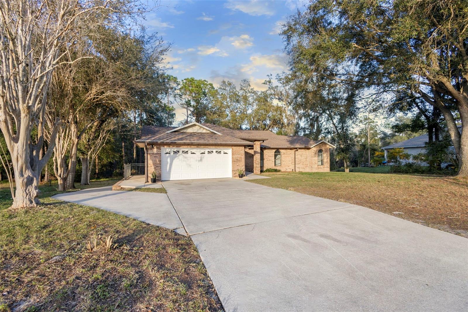 SELLER MOTIVATED • PRICE IMPROVEMENT • ½ ACRE • 1,500 SQ FT BASEMENT • MAJOR UPDATES DONE • Space, privacy, and flexibility bring your RV, boat, or toys! Custom-updated brick home with exceptional parking—2-car garage, extended side driveway, and additional tandem rear garage for RV, boat, or trailer. Major updates include ROOF (5 yrs), A/C & WATER HEATER (3 yrs), and SEPTIC/DRAINFIELD (5 yrs). Bright, open layout with high ceilings, split-bedroom floor plan, and updated kitchen featuring quartz countertops, soft-close cabinetry, and modern appliances. Enjoy a covered patio with no rear neighbors, sunset views, and frequent deer sightings. Conveniently located between Orlando and the beaches—move-in ready with room to grow! Schedule your showing today!!