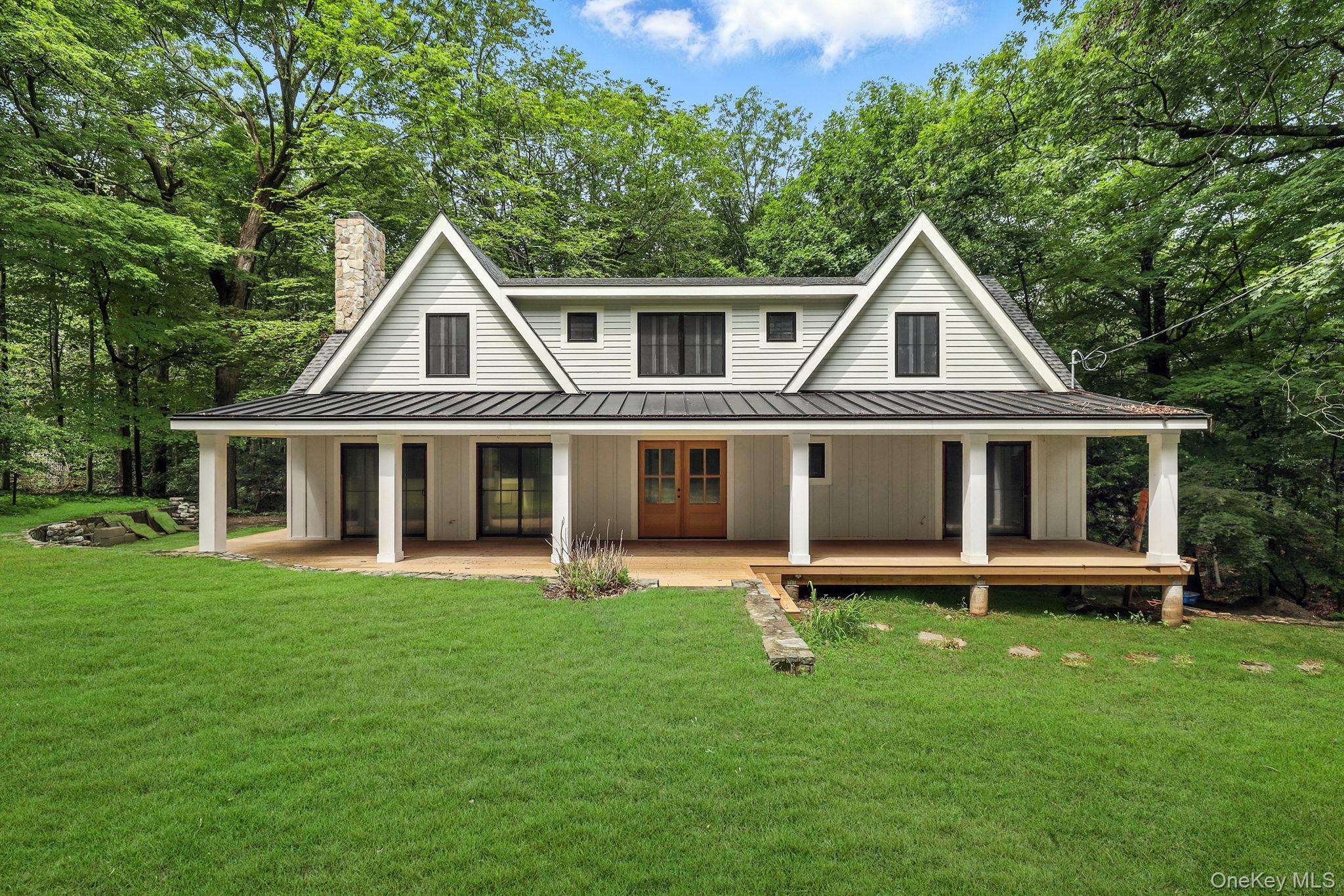 Experience the pinnacle of refined living in this newly reimagined modern farmhouse, perfectly sited on a secluded, tree-lined acre in the heart of Chappaqua. With over 2,800 square feet, this residence blends timeless architectural detail, ready for the buyer’s touch. Andersen 400 series windows and doors throughout, most are six-foot in height, enhance natural light and frame serene woodland views. A dramatic vaulted great room sets the tone with a wood-burning fireplace, opening to a bespoke chef’s kitchen, ideal for elevated entertaining. The floorplan flows effortlessly from an intimate dining area to a cozy mezzanine retreat above. The primary suite is a private sanctuary, featuring a tree-top balcony ready for a spa-level bath plumbed for double vanities, tub, and shower. The lower level is ready for a custom-designed entertainment lounge, plumbed for a wet bar and game room. A charming covered front porch, lush lawns, and a tranquil brook complete this idyllic setting. Nestled just moments from Chappaqua Crossing—home to Whole Foods, Lifetime Fitness, dining, shopping, and medical facilities. Metro-North and major parkways are easily accessible for effortless commuting. Located in the nationally recognized Chappaqua School District.
