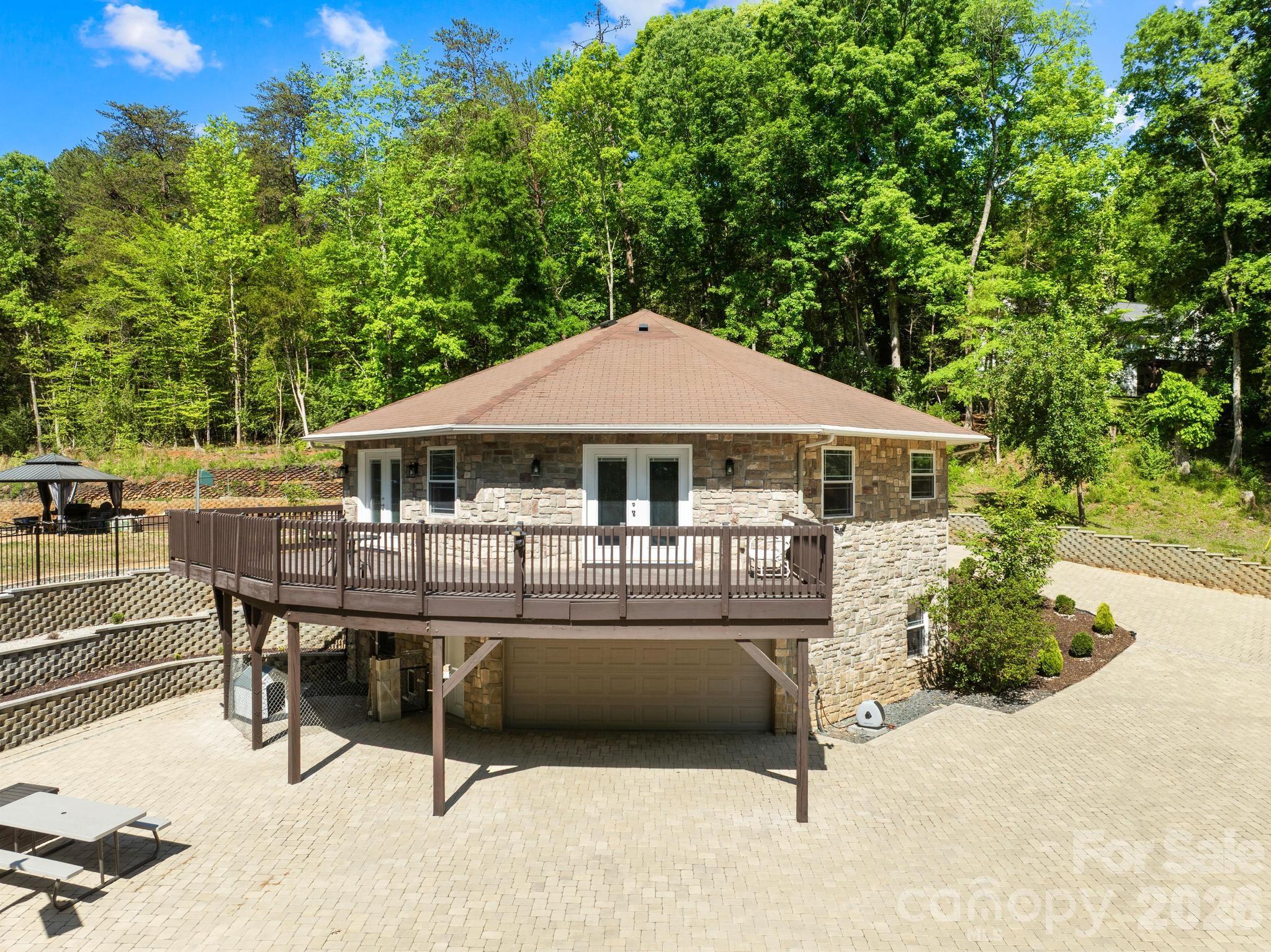 Welcome to a truly one of a kind octagon retreat set on 3 Acres Land with NO HOA in the heart of Charlotte. Tucked away behind a long fully paved winding driveway, this custom built home offers the perfect blend of privacy, character, and lifestyle.Inside, you are welcomed by soaring vaulted beamed ceilings, an open concept layout, and slate and marble flooring that adds a distinctive upscale feel. Natural light fills the space and flows seamlessly to a spacious upper level deck, perfect for relaxing or entertaining while enjoying peaceful wooded views. The home also features beautifully customized bathrooms and a luxurious primary suite with a walk in dressing closet.Step outside and enjoy your own private recreational space with pickleball and volleyball courts, creating a true retreat experience right at home.All of this is just minutes from Charlotte Premium Outlets, Topgolf, SouthPark, and everyday shopping and dining, offering a rare combination of seclusion and convenience. A home like this is more than a place to live, it is a lifestyle.