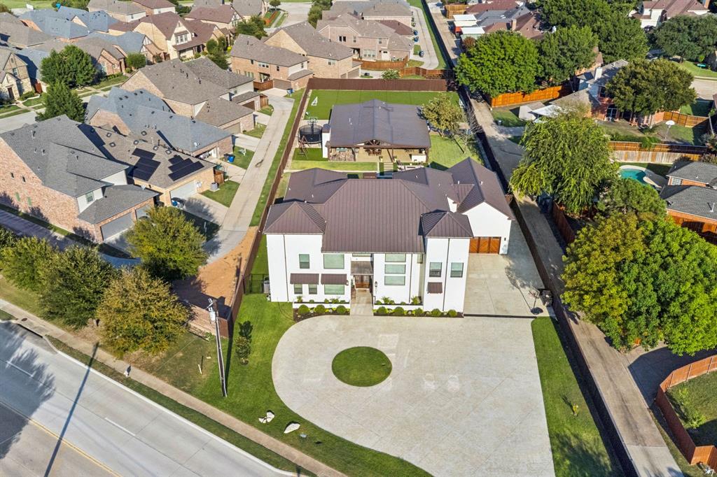 Perfect for entertaining indoors and out, this extraordinary estate offers 6,422 sq. ft. in the main residence plus a 2,202 sq. ft. guest home, combining 8,600+ sq. ft. of luxurious living space. Every detail reflects craftsmanship, comfort, and thoughtful design. Built on a reinforced slab foundation engineered to minimize settling, with hail-impact resistant metal roof and full closed-cell foam insulation, including garage, for efficiency and soundproofing. The living room impresses with soaring 28’ vaulted ceilings, white stone fireplace, custom cabinetry, and chandeliers. The dining room features accent wall, fireplace, coffee-tea bar, and close by a bar with sink, icemaker, and mini-fridge. The spacious kitchen accommodates professional appliances suited for a gas range along with a commercial grade vent hood, double ovens, 4-door refrigerator, dishwasher, pot filler, porcelain farm sink, custom cabinetry, and magnificent quartzite island. Space also features a spacious pantry, mudroom with built-ins, and custom laundry room. The owner’s suite offers backyard access, accent wall, spa-like bath with soaking tub, rainfall shower, dual sinks, and a custom walk-in closet with center island. Additional bedrooms are spacious featuring walk-ins and unique finishes. Amazing amenities to the home include a theater room, office, and gym-guest room. Outdoor living shines with stamped concrete patios, outdoor grills, fire pit, basketball court, dog run, turf yard, retaining wall, and automatic gate. Gas generator provides peace of mind. The guest home, complete with its own kitchen, cedar porch, metal roof, and stained concrete floors, is perfect for extended family, Airbnb, or rental income.
Highlights include custom wood floors, porcelain tile baths, maple doors, pine framing, smart wiring, zoned high-efficiency HVAC, and dual smart irrigation systems.
Buyer and buyer’s agent to verify all information. Information deemed reliable but not guaranteed.
