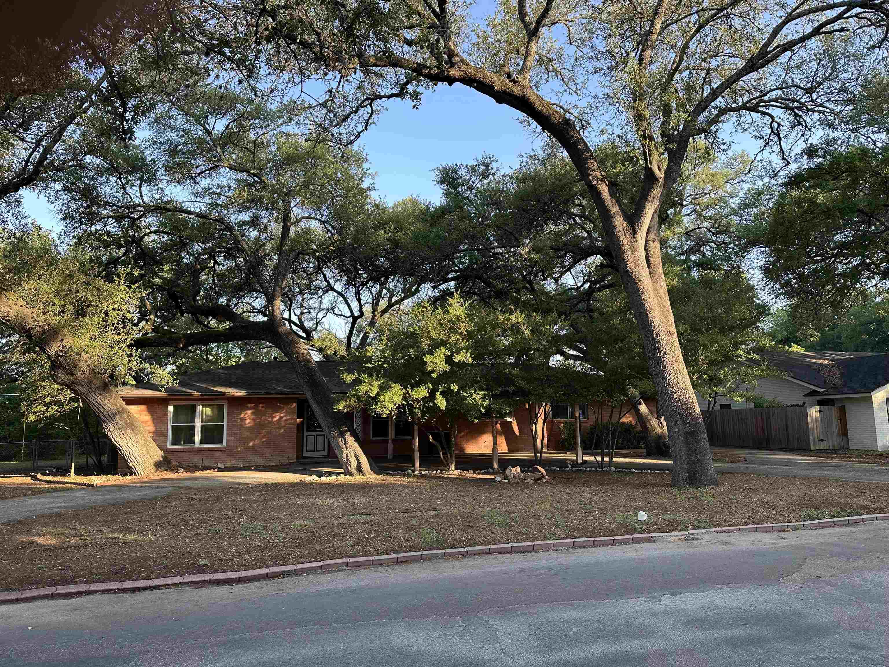 Nestled on a quiet dead-end road in a highly desirable area of Marble Falls, this property offers the perfect opportunity for those looking to take on a fixer-upper project with great potential. Situated on just under half an acre, the lot is shaded by mature oak trees that create a peaceful, park-like setting. The home itself is older and ready for renovation, making it an ideal canvas for investors or buyers looking to customize a property to their own style.  The property features a circle driveway, a two-car carport, and ample yard space for outdoor living, additions, or landscaping improvements. With its unbeatable location this home is full of possibilities—bring your vision and make it your own.