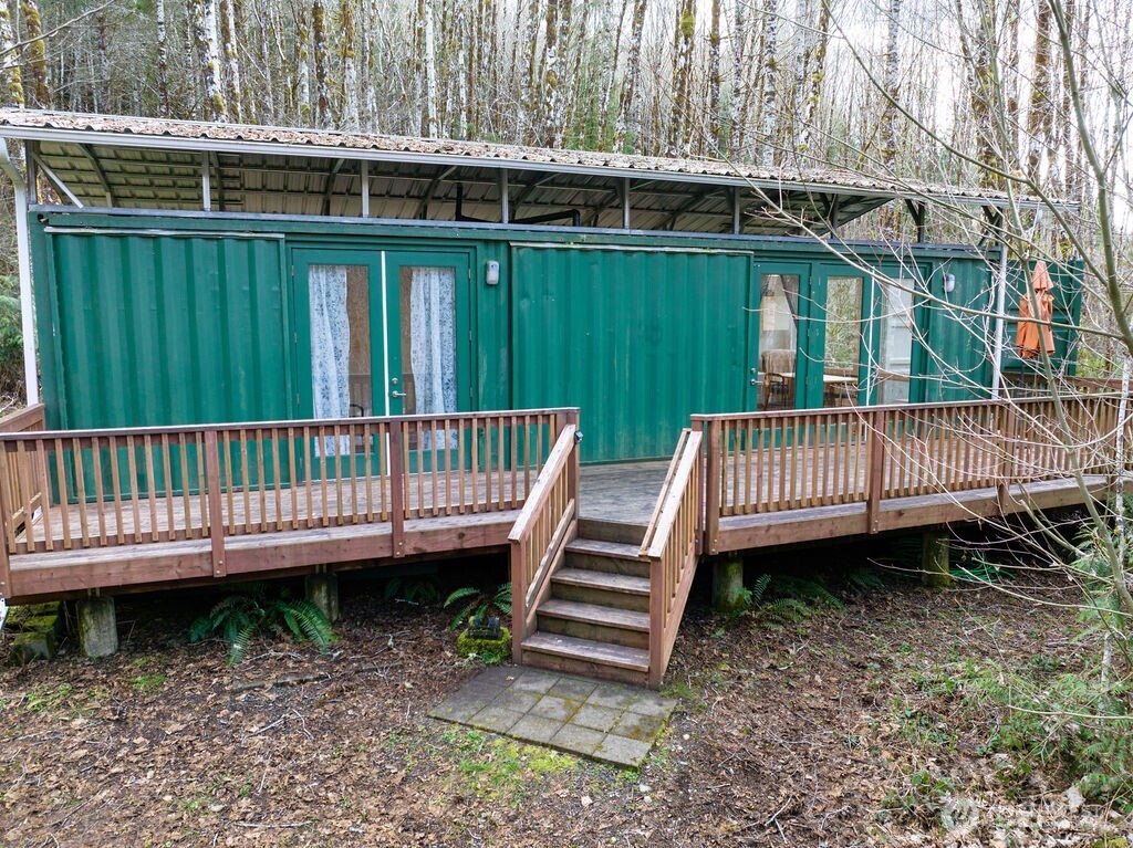 Escape the city and discover your own private retreat with this unique container home, thoughtfully designed and set on over 9 serene acres of forested land. Tucked away in nature, this hidden gem offers the perfect balance of modern comfort and peaceful seclusion. Inside, the home features two cozy bedrooms and a beautifully finished ¾ bathroom, all complemented by an open-concept living area that maximizes space and natural light. Expansive windows bring the outdoors in, filling the space with sunlight and offering peaceful forest views from nearly every angle. Clean lines and smart design create a warm, inviting atmosphere ideal for relaxing or entertaining. Step seamlessly outside through elegant French doors that open onto both the front and back decks perfect for indoor-outdoor living. Enjoy your morning coffee on the front deck or unwind in the evening on the back deck, surrounded by the sights and sounds of nature and beautiful natural stream and pond. The property also includes an outdoor shed, providing convenient storage for tools, gear, or recreational equipment. As the sun sets, gather around the fire pit and enjoy peaceful summer nights under the stars. Whether you’re looking for a full-time residence, a weekend escape, or a unique investment opportunity, this one-of-a-kind property offers privacy, charm, and a true connection to nature.