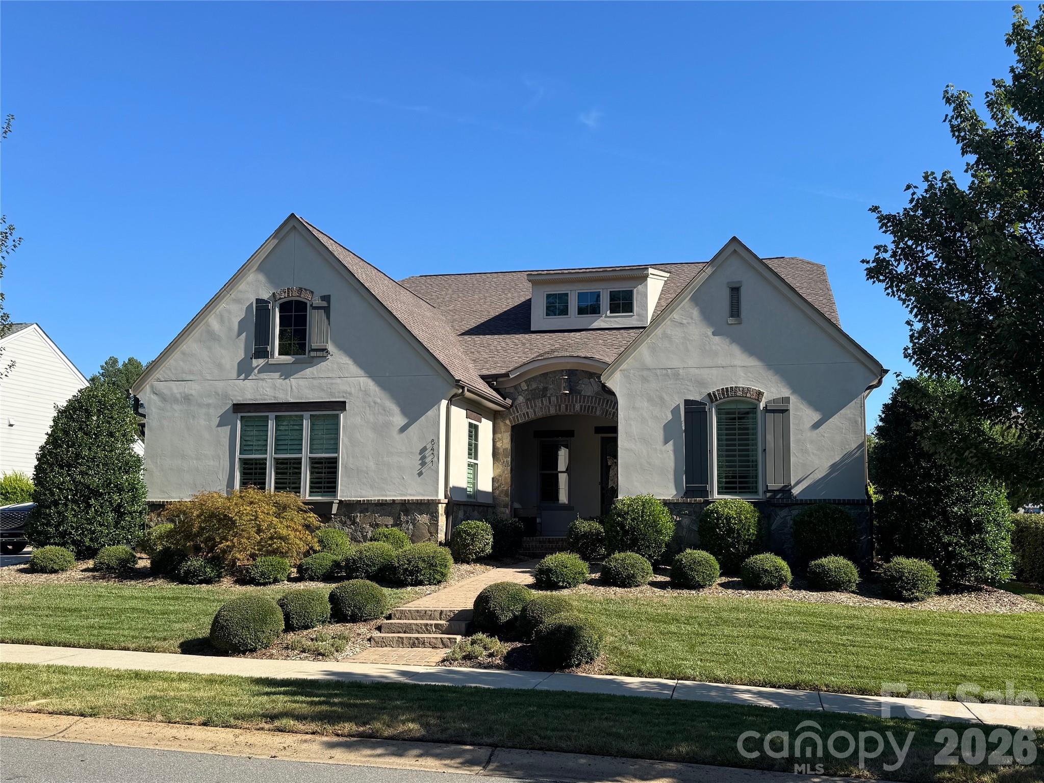 Better than new, this exceptional custom home in the highly sought-after Torance community blends superior craftsmanship, timeless elegance, and upscale amenities. Built in 2019, this 2,900-square-foot home features 3 bedrooms, 2.5 bathrooms, and an expansive 3-car garage.  The meticulous care and thoughtful design gives the feel of a resort rather than a home. At the heart of the home is a spectacular gourmet kitchen outfitted with a 5-burner gas cooktop and upgraded stainless steel appliances, perfect for the passionate home chef. The kitchen flows effortlessly into the main living room, centered by a cozy, elegant fireplace. Enjoy your favorite music seamlessly throughout the property with high-end, whole-house audio speakers.Retreat to the beautiful owner's suite, spa like primary bathroom with his and her vanities and a luxurious soaking tub.The primary suites generous walk-in closet has been fully customized with premium built-ins, offering sophisticated organization and design. Direct access to the laundry room from the primary closet makes even mundane chores effortless. Transition to outdoor luxury through striking accordion doors that fold completely open, expanding your living space into a true backyard oasis. Spend your days lounging by the sparkling, heated saltwater pool, beautifully framed by elegant travertine decking. The outdoor experience is enhanced by a premium covered patio with an electric screen enclosure and its own outdoor fireplace, creating the ultimate ambiance for evening gatherings. As the sun sets, custom uplighting beautifully illuminates the professionally landscaped yard.Situated on a generous 0.32-acre lot, this home blends high-end architectural detail with an unbeatable location close to Birkdale Village and Lake Norman. Don't miss your chance to own this turnkey entertainer's dream!