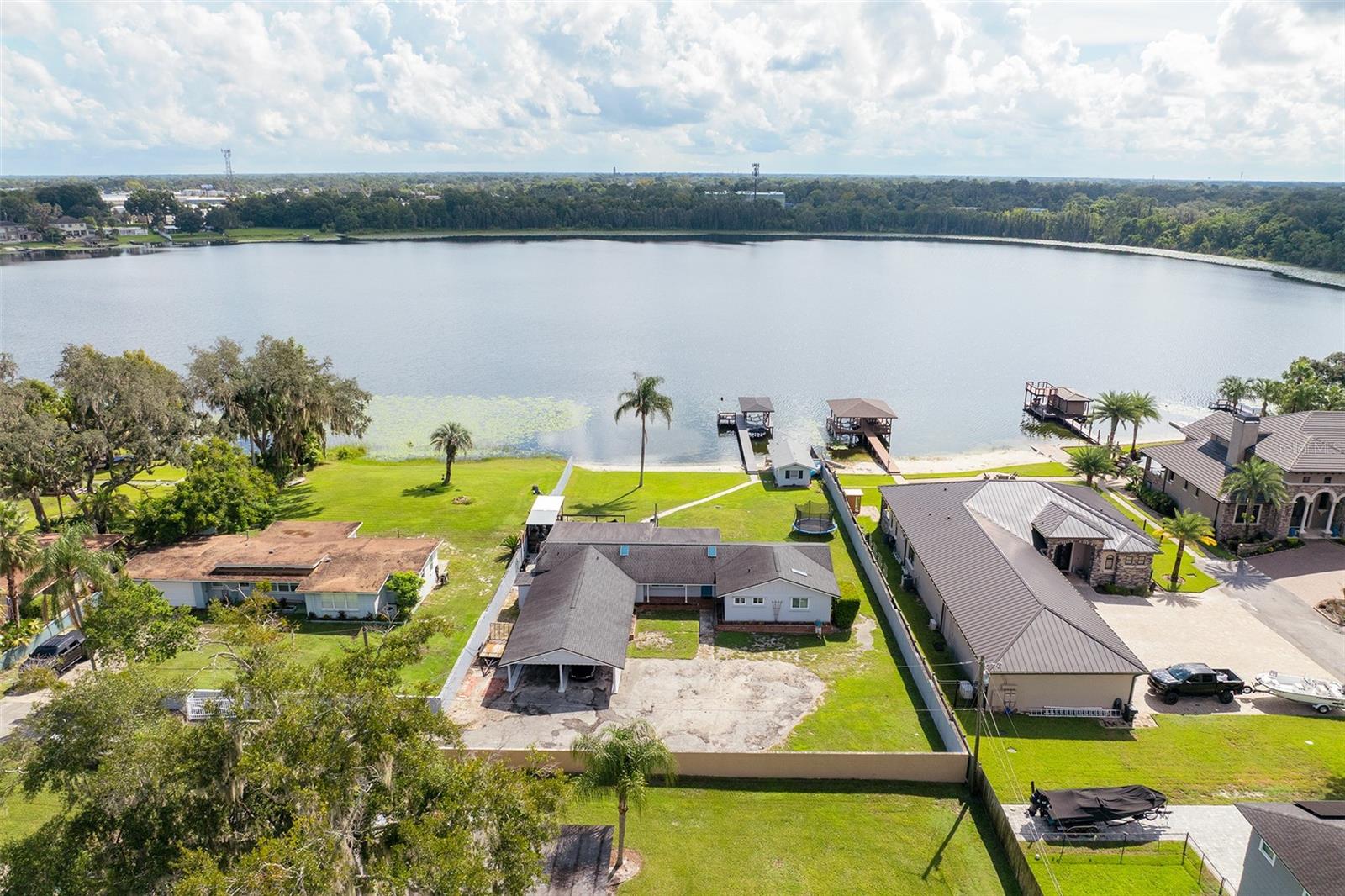 Extremely rare opportunity to own an exceptional lakefront property in the heart of Maitland. This four bedroom, two bathroom residence has been tastefully renovated and is set on 1.07 acres of land along the sandy beach shores of Lake Seminary. It offers the combination of privacy, land, water access and beautiful renovations. The heart of the property is the spring fed lake known for recreational boating and water activities. The private sandy beach leads to a new 90 x 4 ft dock with a 12 x 12 ft recreational pad and bench. It's made of Trex composite decking and features an electric boat lift and cold water hose, making it easy to enjoy everything the lake has to offer. The property also boasts of a concrete block boathouse with electricity, adding valuable storage and functionality for lake life. Inside, the home has been completely renovated with an emphasis on quality, comfort and everyday living. The kitchen has been beautifully updated with stainless steel appliances, new cabinets, stone counters and a large island with seating for four. It has a panoramic view of the lake as it opens seamlessly to the dining/family room which highlights expansive sliding glass doors that lead directly out to the deck and backyard oasis. The extensive improvements continue throughout the property with renovated bathrooms, new vinyl wood flooring, fresh interior/exterior paint, new doors, new windows, new electrical, a new roof (2019), new skylights, two new air conditioning systems with new ductwork (2020), a new water softener and a commercial grade propane powered on demand tankless water heater. There's a separate indoor laundry room which provides generous space for folding and a 319 sqft bonus room with private access to the exterior. Outside, the new wood deck overlooks the lake and includes a mosquito prevention system, an outdoor shower and plumbing already in place for a sink. There's also new seamless gutters and a concrete security wall that surrounds the perimeter of the property with an electric access gate. This rare lakefront property offers the ultimate Central Florida lifestyle with private lake access and recreation at home, while being just minutes from exceptional dining, boutique shopping, Lake Lily, vibrant downtown Maitland, Winter Park’s renowned Park Avenue, and major roadways.