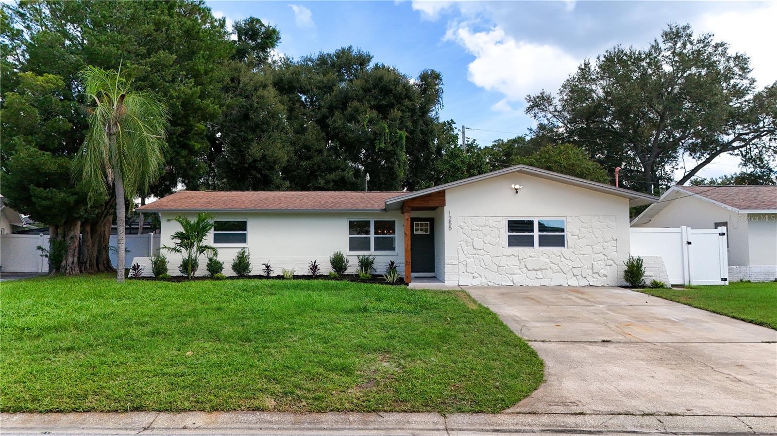 Completely renovated from top to bottom, this Dunedin home delivers a fresh, modern feel with thoughtful finishes throughout. The open-concept layout features new LVP flooring, lighting, fixtures, fresh paint, and a beautifully redesigned kitchen with custom cabinetry, stone countertops, recessed lighting, stainless steel appliances, modern backsplash and a peninsula with bar seating that flows seamlessly into the living area. A custom bar with additional cabinetry and a wine fridge adds an impressive touch for entertaining. Both bathrooms have been completely updated, while the spacious primary suite offers a walk-in closet and private en-suite bath with dual sinks and a walk-in shower. A new HVAC system adds peace of mind and the large fenced backyard provides plenty of room to relax, play, entertain, or enjoy the Florida sunshine, plus a storage shed for added convenience. Located in desirable Dunedin, you're close to Honeymoon Island State Park, the Dunedin Causeway, Caladesi Island, the Pinellas Trail, Hammock Park, downtown Dunedin, waterfront parks, local dining, shopping, breweries and entertainment. Clean, stylish, move-in-ready, and ideally located, schedule your private showing today and see everything this home has to offer!