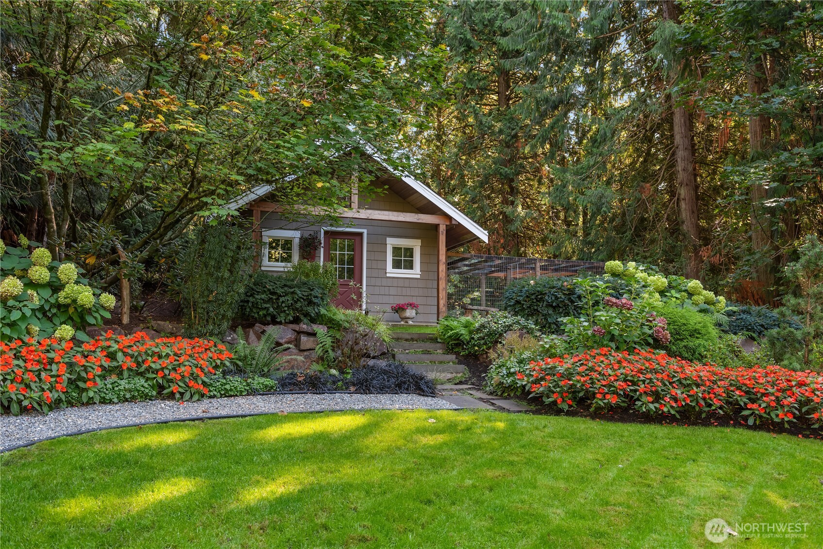 Garden shed with red door surrounded by flowering landscape