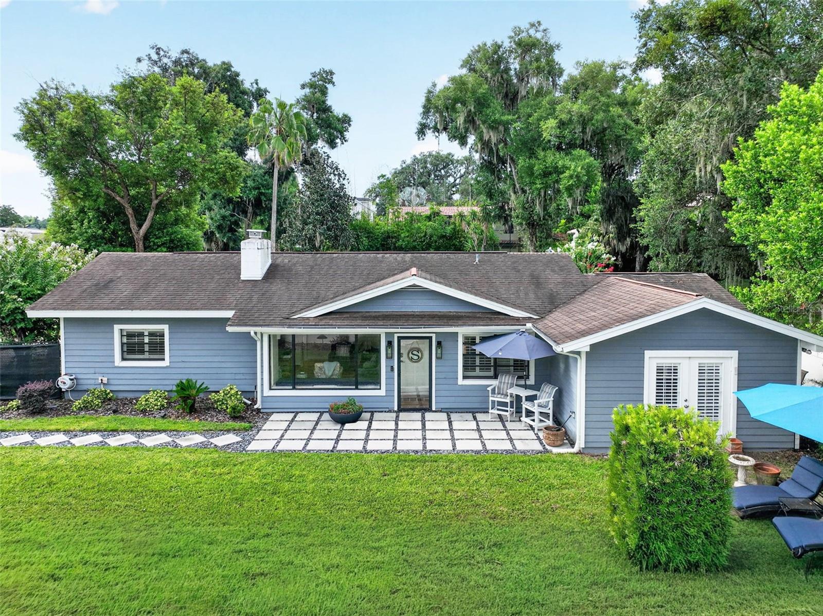 A truly unique opportunity to own well over half an acre of ultra-private property, set far back from the road, with 12 feet of deeded Lake Sybelia frontage and access. This charming, updated, cottage-style home offers 3 bedrooms plus a den, 2.5 bathrooms, and plenty of separate flex space for entertaining, both inside and out. The family room is light and bright with skylights, terracotta-look tile floors, a beamed ceiling, a window seat, and brick mantle. The inviting kitchen features smoky blue cabinetry, a farm sink, new refrigerator, tile counters and floors, and opens to the dining room and a light-filled sitting room with built-in wet bar, wine storage, and accordion doors opening to the backyard. The adjacent Florida room has walls of windows overlooking the yard and a door leading to the backyard. The split-bedroom floor plan offers two bedrooms sharing an updated hall bath with tile floors, quartz counters, dual sinks, and multiple showerheads, including a rain shower. The separate primary suite, part of the 2001 addition, is spacious with three closets and French doors opening to a brick patio. The primary bath features a single-sink vanity, built-in cabinetry, and shower. An attached den with a half bath and closet provides flexible space for an office, nursery, or additional sitting area. Additional features include wood floors in all bedrooms, ceiling fans, plantation shutters, a water softener, and interior laundry. Recent updates include roof (2019), AC (2023), insulation (2025), electric panel (2024), hot water heater (2026), lighting, fixtures, a new electric fence, and more. A long private driveway leads to a large circular drive at the rear of the property. A detached shed has electricity and running water. The fully fenced backyard offers mature landscaping, in-ground irrigation, and ample space and flexibility for outdoor living, entertaining, RV or boat storage, or for future improvements, additions, or to create a custom new build.  The property includes a deeded 12-foot-wide strip of Lake Sybelia frontage, providing usable lake access and potential for an EZ floating dock; see survey/attachment for details. Ideally located near the new Maitland Public Library, currently under construction and expected to open in 2027, as well as the Enzian Theater, Maitland Art & History Center, and Lake Lily Park, and just minutes to Winter Park and Downtown Orlando. Assigned schools include Lake Sybelia Elementary, Maitland Middle, and Edgewater High. Lot size is approximately 0.65 acres per public record, including the portion of the parcel extending into Lake Sybelia; approximately 0.58 acres is dry land. Buyer to verify all measurements, property boundaries and lake access.