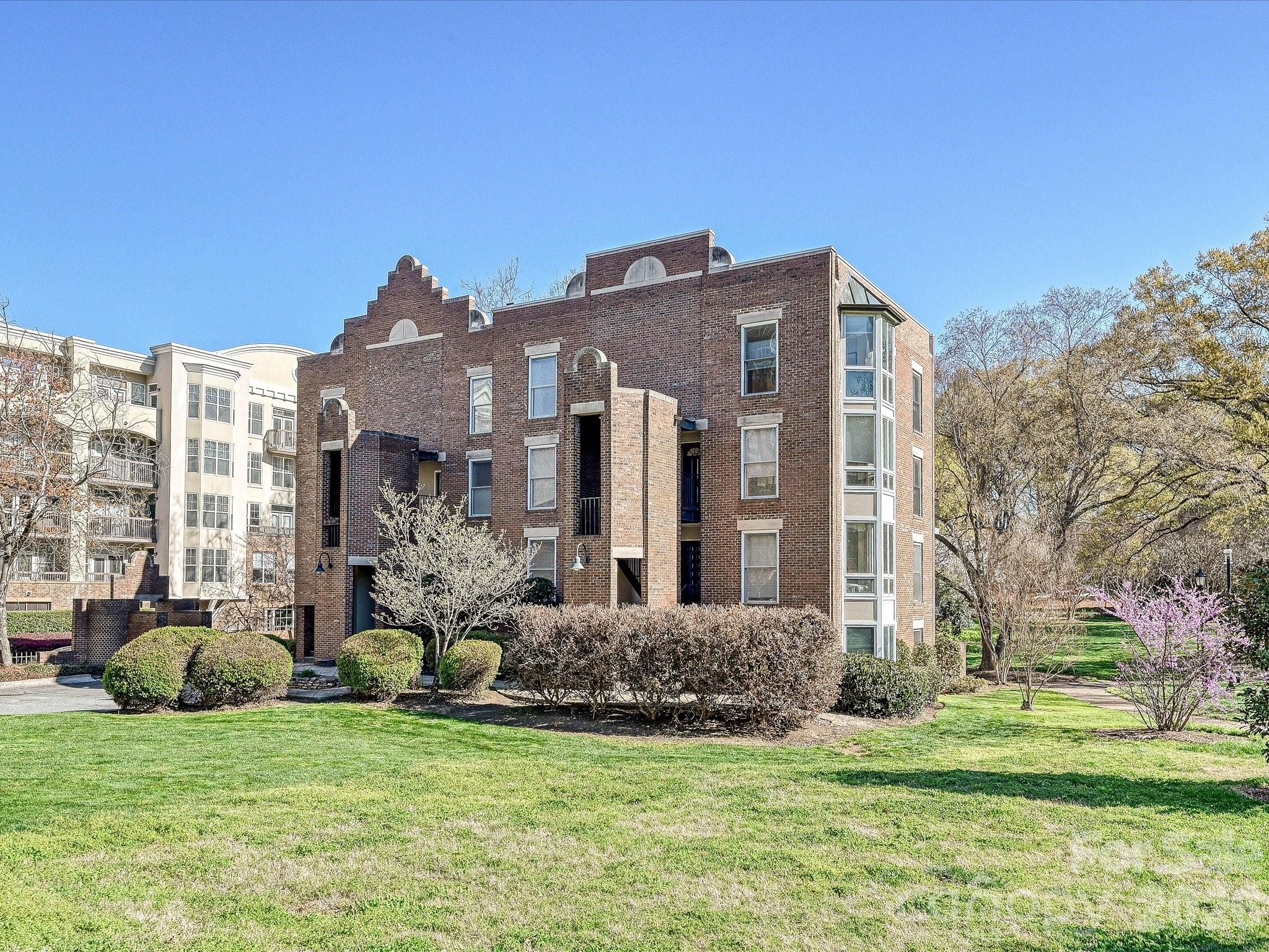 Hidden Gem in Fourth Ward Park! This charming top-level, two-story end-unit condo is nestled in the heart of Fourth Ward with abundant natural light from multiple bay windows. 2 deeded parking spots just steps away from the building. Thoughtfully updated throughout, it features an open floor plan with a renovated kitchen, stainless steel appliances, hardwood floors, exposed beam ceilings, custom built-in storage throughout, and a cozy fireplace. The spacious primary suite includes a large bath with a soaking tub and separate shower. Enjoy a private balcony overlooking the park, two parking spaces, and low monthly dues. Refrigerator, washer, and dryer are included. Low HOA dues. All of this just steps from restaurants, grocery stores, shops, and sports venues—experience the best of uptown Charlotte living!