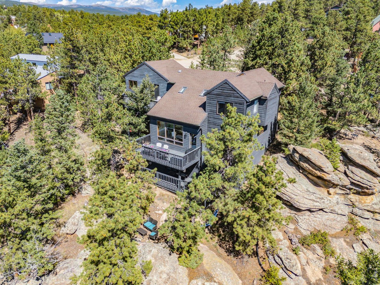 Spectacular location in Nederland's premier Sunnyside subdivision, overlooking the charming Town of Nederland with sweeping views of snow-capped peaks and surrounding mountains. This well-designed home features an open floor plan with a large air-lock foyer and sun-drenched spaces throughout, all oriented to capture incredible light and views. Nestled among beautiful rock outcroppings, this property offers a rare combination of privacy and convenience just a short walk to downtown Nederland, the elementary school, trails, restaurants, breweries, shops, grocery stores and the local movie theater. Enjoy quick access to outdoor recreation year-round, including nearby Eldora Ski Resort. Recent improvements include updated carpet and brand-new LVP flooring, along with updates to 3 of the 4 bathrooms. The primary suite is a true retreat with a private balcony showcasing Divide Mountain views, a versatile bonus room ideal for an office, yoga space, or nursery, a large walk-in closet and 5-piece bath. The walkout lower level has a separate entrance and has been thoughtfully converted into a successful short-term rental unit, offering excellent income potential ($22K in 2025) or flexible multi-generational living. Additional upgrades include a whole-house natural gas generator that automatically provides reliable backup power during outages. Set well back from the road, this private mountain home features 3 separate decks for enjoying the outdoors, ample storage throughout and a layout that offers both comfort, flexibility & mountain views. A rare opportunity to own a well-built home with strong bones, modern updates, unbeatable views and exceptional location in one of Nederland's most desirable neighborhoods.