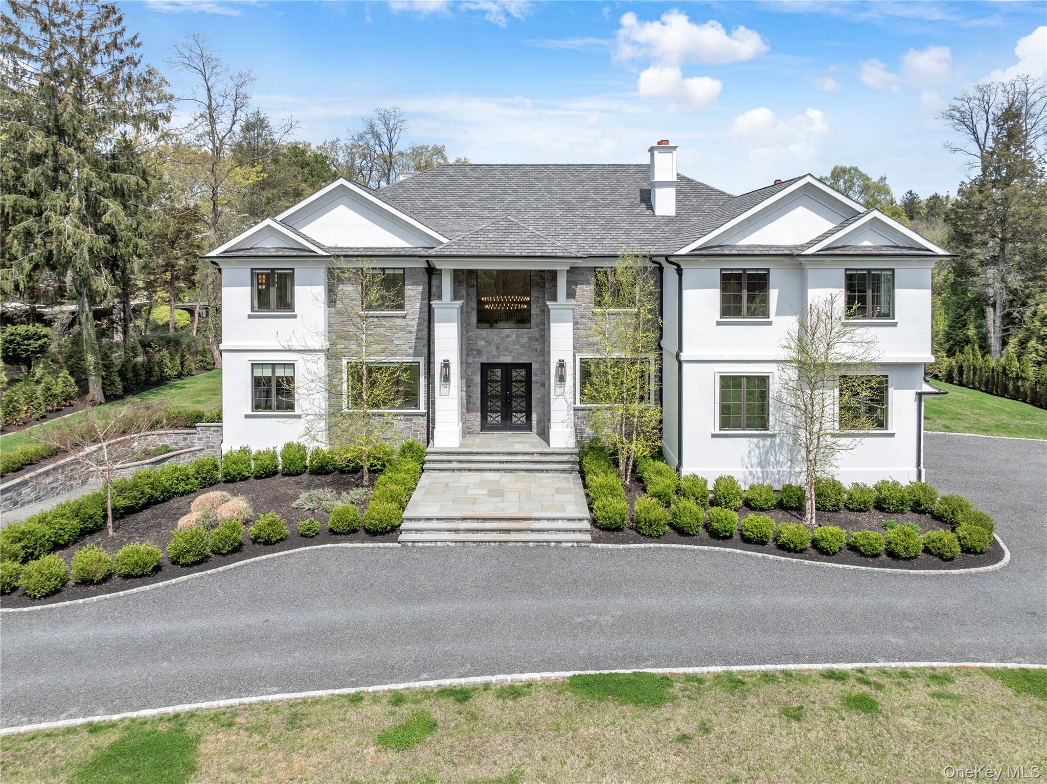 Welcome to 5 Gerry Lane, a newly built 2024 estate by Cortazar & Sons Builders set on two private acres backing the Target Rock National Wildlife Refuge in the Village of Lloyd Harbor. Offering nearly 8,500 square feet, this custom home features 5 en suite bedrooms, 6.5 baths, and a dramatic 22 foot foyer with 10 foot ceilings on 1st floor and 9 foot ceilings in basement and on 2nd floor.Designed for modern living and entertaining, the home includes a chef’s kitchen with Thermador appliances, Calcutta Oro marble countertops, and an expansive island, opening to a spacious great room with oversized windows and wide plank white oak floors. A first floor en suite bedroom provides flexibility for guests or office use.The primary suite offers a spa like bath with radiant heated floors, soaking tub, and custom shower. Three additional en suite bedrooms complete the second level, with select rooms opening to a balcony overlooking preserved land.The finished lower level includes a recreation area, gym, and a driveway accessed garage bay designed for car collectors. Additional highlights include a 3 car garage, smart thermostats, bluestone patios, circular driveway with gates, and room for a custom pool.Located within walking distance to a private beach via Hawk Beach Association with dock access. Convenient to Caumsett State Park, Huntington, Cold Spring Harbor, and the train to Manhattan.
