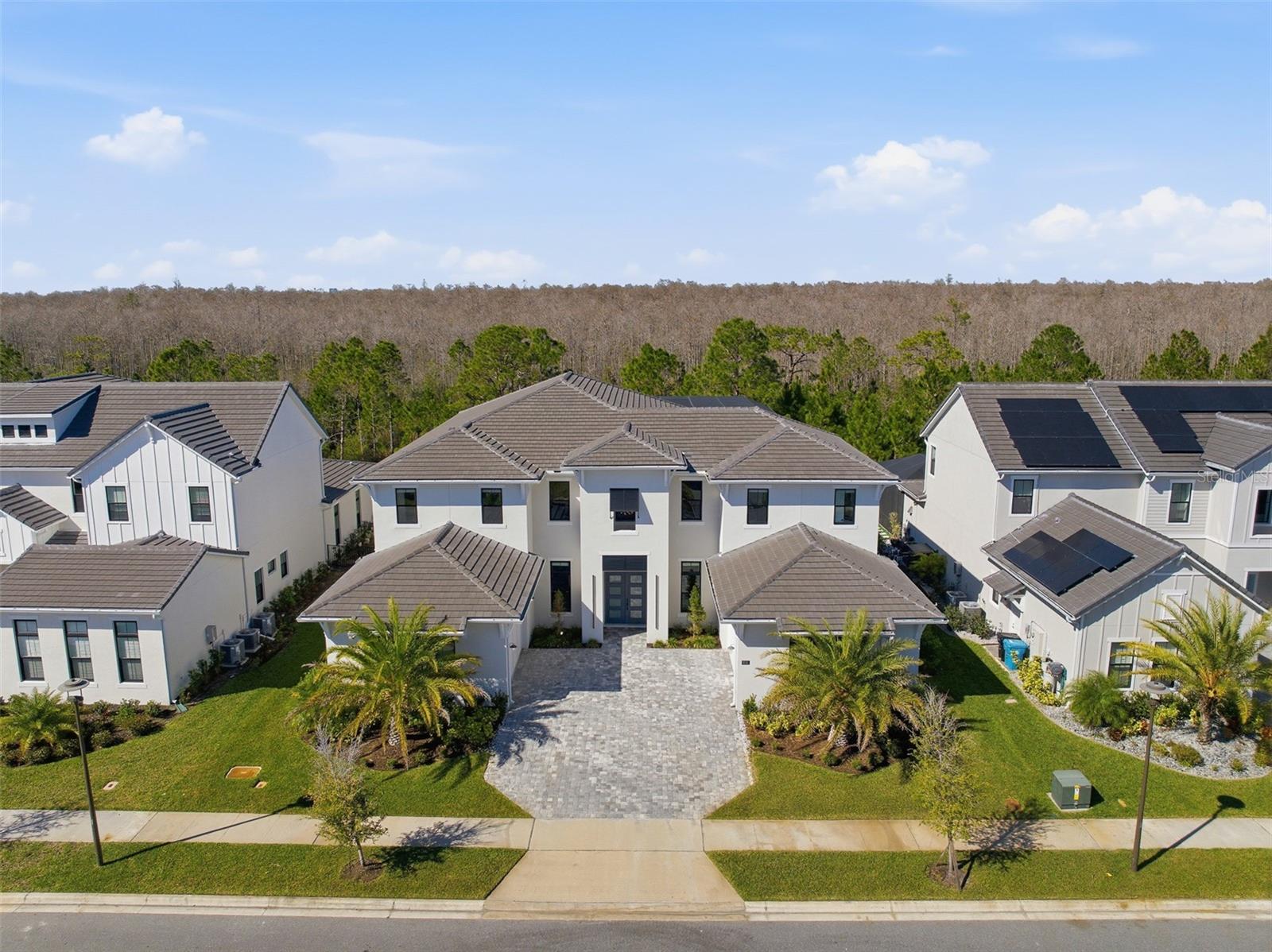 One or more photo(s) has been virtually staged. HUGE Price Reduction!!!! Luxury, privacy, and an exceptional lifestyle converge in this extraordinary estate located within Laurel Pointe, Lake Nona’s exclusive 24-hour gated enclave of just 124 custom homes. Ideally positioned in the heart of Lake Nona, this home offers effortless access to Medical City, Boxi Park, Orlando International Airport, USTA, KPMG, premier shopping and dining, and is within two miles of SR-417 and SR-528, providing seamless travel throughout Central Florida. Built by Toll Brothers, this impressive VAREN Model sits on a lush, oversized conservation lot and showcases over $1,000,000 in thoughtfully curated upgrades, delivering a truly custom living experience. Constructed primarily of solid block on both levels and enhanced with additional insulation throughout (including both garages), the home features double-paned insulated windows, solid core interior doors, EV charging, dual 200-amp garage services with a 400-amp disconnect, and infrastructure designed for longevity, comfort, and efficiency. Spanning nearly 6,700 square feet, the open and light-filled floor plan offers five en-suite bedrooms, including the primary and a secondary suite on the main level, with three additional suites upstairs. Soaring 30-foot ceilings, dramatic dual wood staircases with modern custom railings, and premium finishes throughout create a striking first impression from the moment you enter through the covered entry and double front doors. The chef’s gourmet kitchen is a masterpiece, featuring professional-grade stainless steel appliances, extended custom cabinetry, a massive island with seating, glass inlays, accent lighting, built-in coffee and cappuccino machine, under-counter wine refrigerator, and a spacious walk-in pantry. Designer lighting, tray ceilings with crown molding, custom wall treatments, premium flooring, and floor-to-ceiling tile in every bathroom elevate the home’s refined aesthetic. Designed for both productivity and entertainment, the residence includes dual executive offices (one on each level), a spacious upstairs loft, and a massive media and movie room. Storage is abundant, complemented by two oversized double-car garages, each with insulated doors and private home entry. One garage features a custom mudroom adjacent to the large walk-in laundry room with utility sink, upgraded cabinetry, AV hub, and natural light.The outdoor living experience is nothing short of spectacular. A $275,000 resort-style pool and spa with elevated retaining wall, spraying deck jets, bubbling sun shelf, and panoramic two-story screened enclosure overlooks a tranquil conservation backdrop. The covered lanai includes a full outdoor bath with shower, an incredible summer kitchen, and ample space for dining, entertaining, and relaxing in complete privacy.Smart-ready and tech-forward, the home offers app-controlled pool systems, lighting, locks, enhanced WiFi with Cat-6 hard-wired connections, and built-in surround sound throughout the great room, kitchen, primary suite, and outdoor living areas. This is a rare opportunity to own a truly exceptional Lake Nona estate—one that seamlessly blends sophistication, comfort, privacy, and premier location to accommodate the most discerning buyer. Schedule your private showing and experience this remarkable home firsthand.