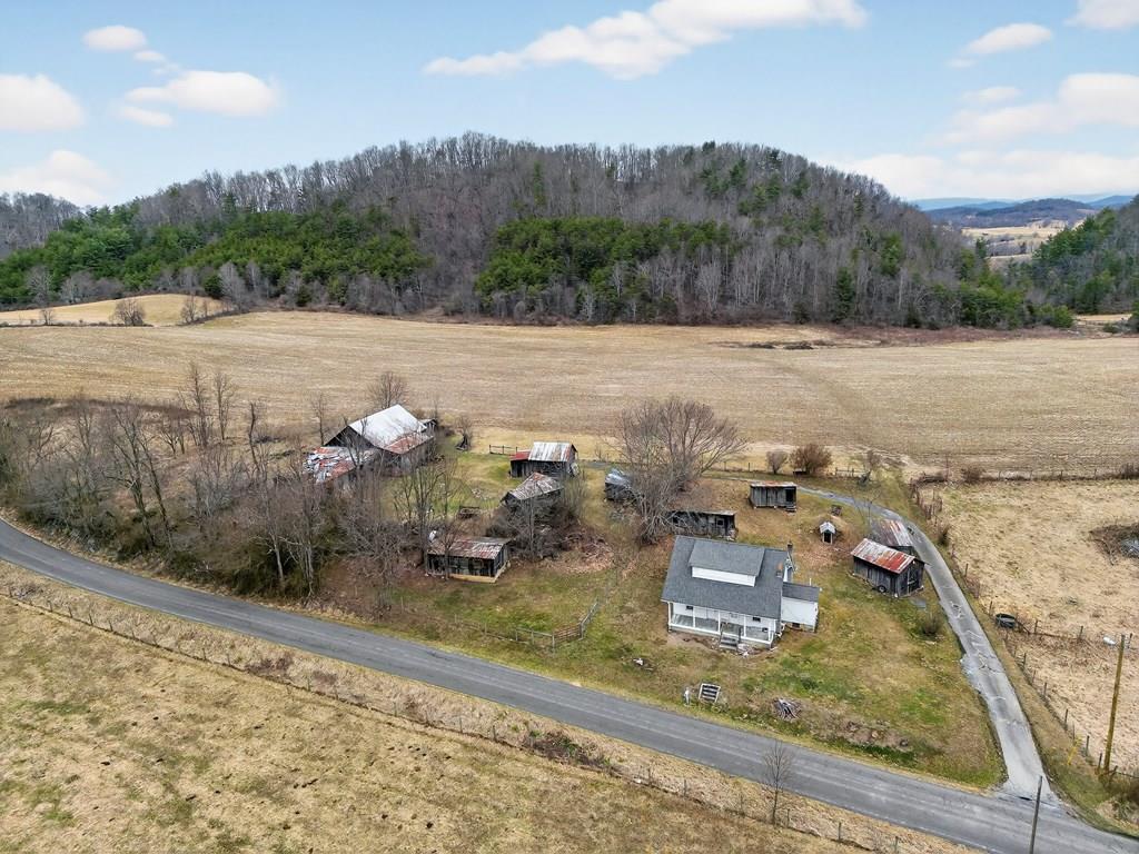 PRICE ADJUSTMENT DUE TO SALE OF PARTIAL ACREAGE.  THIS PROPERTY NOW INCLUDES one 75.01 ac+/- parcel and the house parcel on 1.4 acres for a total of 76.41 ac +/-.  Situated in the scenic countryside of Wideners Valley, this unique property offers the opportunity to own a substantial tract of land along with a classic farmhouse and multiple outbuildings suited for a variety of uses. The listing includes a newly surveyed 1.4-acre parcel containing a four-bedroom, one-bath home, along with an additional parcel totaling an impressive 76.41 acres.  The home features two bedrooms on the main level and two additional bedrooms upstairs. While the house does need work, it provides a solid starting point for those looking to restore a traditional country home or establish a rural homestead. Public water is already connected to the home.  The property is complemented by multiple barns and homesteading-style outbuildings, offering ample space for storage, livestock, equipment, or workshop use. The surrounding land provides a diverse and highly usable landscape, including a field of mostly-level, cleared and tillable ground that would be well suited for farming, pasture, or other agricultural pursuits and another portion of acreage which is wooded - providing privacy, natural beauty, and abundant wildlife habitat.  A pond adds to the appeal of the property, creating an attractive focal point and additional recreational potential. With hundreds of feet of road frontage along Wideners Valley Road and Cherry Tree Road, the property offers excellent access and flexibility.  Whether you are looking for a large agricultural property, a place to establish a homestead, or simply a substantial tract of land with a home and multiple outbuildings, this property offers space, versatility, and opportunity in a peaceful rural setting.  Please note:  Property has a Chilhowie address, but is situated in Washington County, VA.