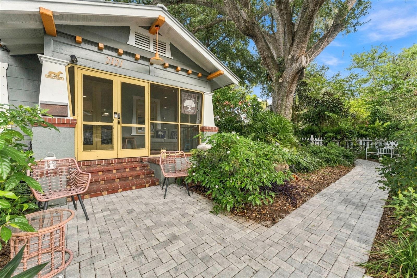 Brick streets, shady oaks, and front porches that actually get used: this is Historic Kenwood, one of St. Pete's most cherished neighborhoods, and this lovingly restored 1925 craftsman bungalow is a standout on its oversized, high and dry lot with no flood insurance required! In the main house, a screened front porch welcomes you into a bright living room with original hardwood floors, soaring ceilings, and a wood-burning fireplace, while the updated kitchen pairs quartzite counters and premium appliances, including a Viking gas range, with a generous island and a peaceful view of the garden fountain. The kitchen opens to an expansive lanai made for entertaining, a full natural gas outdoor kitchen, and a private outdoor shower just steps from the saltwater, gas-heated pool with a sun shelf, so the backyard truly works all year long. Both bedrooms offer their own updated ensuite baths, and the big-ticket items are already handled with permitted upgrades including a 2024 metal roof with hurricane clips, 2020 HVAC, 2025 gas tankless water heater, 2025 whole house surge protector and new breakers, a 2020 updated panel, select windows replaced in 2024, plus 2022 plantation shutters and hurricane covers. Behind the main home, a detached one-bedroom, one-bath ADU, rebuilt from the studs in 2021, has its own full kitchen, washer and dryer, new windows, a 2024 metal roof, and indoor/outdoor living space, making it perfect for guests, family, or rental income without sacrificing privacy. The current tenant is month to month and would like to continue renting, offering instant rental income for the new owners! Alley access provides room for three cars, and the location is hard to beat: the Kenwood Dog Park is nearby, the restaurants, breweries, and galleries of the Grand Central District are an easy stroll away, and downtown St. Pete is just a mile down the road, all wrapped in a close-knit community full of character where this home offers far more than four walls, it offers a way of life.
