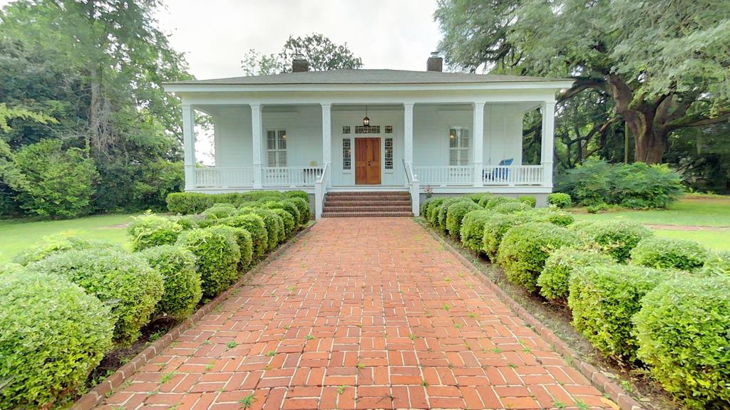 One of the oldest and most distinguished homes in Thomasville, Georgia. The Wright House, Built in 1854 for Arthur P. Wright, a former mayor of Thomasville, is a stately Antebellum Home exuding timeless charm and historic significance. Nestled on a corner lot spanning 1.39 acres, this fully fenced estate offers six gated entries and is listed on the National Register of Historic Places. Once a beloved bed and breakfast, the home has undergone a meticulous, top-to-bottom restoration, blending 19th-century character with modern amenities. Your arrival begins at the oversized front porch, framed by an impressive, recessed entry with pedimented Greek Revival moldings and a row of dentils. The paneled double doors are flanked by glass sidelights and delicate rosettes, opening into a grand double foyer with soaring heart pine ceilings, coved doorways, and crown molding inset with soft ambient lighting. Original and reclaimed crystal chandeliers glitter above, some rescued from historic sites across Georgia. Steeped in charm, inside, the rich architectural heritage is unmistakable. Lintel moldings, soaring ceilings, and governor-paneled walls set the tone, complemented by plantation shutters, heart pine and parquet flooring throughout. Pocket doors, Victorian transoms, and five working gas fireplaces evoke a time gone by, while recessed and pendulum lighting blend seamlessly with the home's character. The gourmet kitchen is a chef's dream — fully equipped with Viking appliances, including a gas range and double wall ovens. A large custom built granite-topped island with sink, offering seating for four all framed by heart pine and parquet floors. The adjacent breakfast nook at the bay window offers peaceful views of the lush backyard. Repurposed materials from the Wickey House were used throughout, tying the past beautifully into the present. The primary suite is a luxurious retreat, complete with a serene sitting area, a very spacious walk-in closet, and a fully restored bath. Indulge in the oversized step-in tile shower with a rainfall fixture and built-in seating, dual granite-topped vanities, and original stained-glass windows salvaged from the Wickey House. Guest rooms offer comfort and charm, sharing a luxurious pass-through powder room featuring a  granite-topped vanity sink and a classic clawfoot tub with shower. Just beyond the kitchen lies a flexible space ideal for a home office or reading nook as you approach the primary suite. The attic is floored and expansive enough to transform into a quiet library, a creative studio, or even a small loft style apartment. Down below, a semi-finished cellar with concrete floor and poly encapsulation offers additional storage or hobby space. The grandeur continues outside with an expansive open-air deck overlooking a serene, private backyard. Towering oaks, pecan trees, gecko garden, flowering azaleas, and fruit trees surround the space, while a brick BBQ grill and large concrete pad await your design touches. Two 220-volt hookups make the area RV/camper-ready. A detached two-car garage with power and an available raised irrigation system (currently not in use) support both convenience and comfort. Despite its age, The Wright House is updated for today's living: a 24kw whole-home Kohler generator, two brand new dual-pump HVAC systems and duct work, new plumbing and electrical systems throughout, a gas tankless water heater, and a brand-new roof. This property not only offers a home but a lifestyle. Located within walking distance of the Ritz Amphitheatre, Paradise Park, and vibrant Downtown Thomasville, you'll find yourself immersed in Southern charm, culture, and community. This is more than a home — it's a rare opportunity to own a piece of Thomasville's rich history. For discerning buyers who appreciate timeless architecture, refined restoration, and the elegance of a bygone era, this legacy property is waiting to be part of your story.