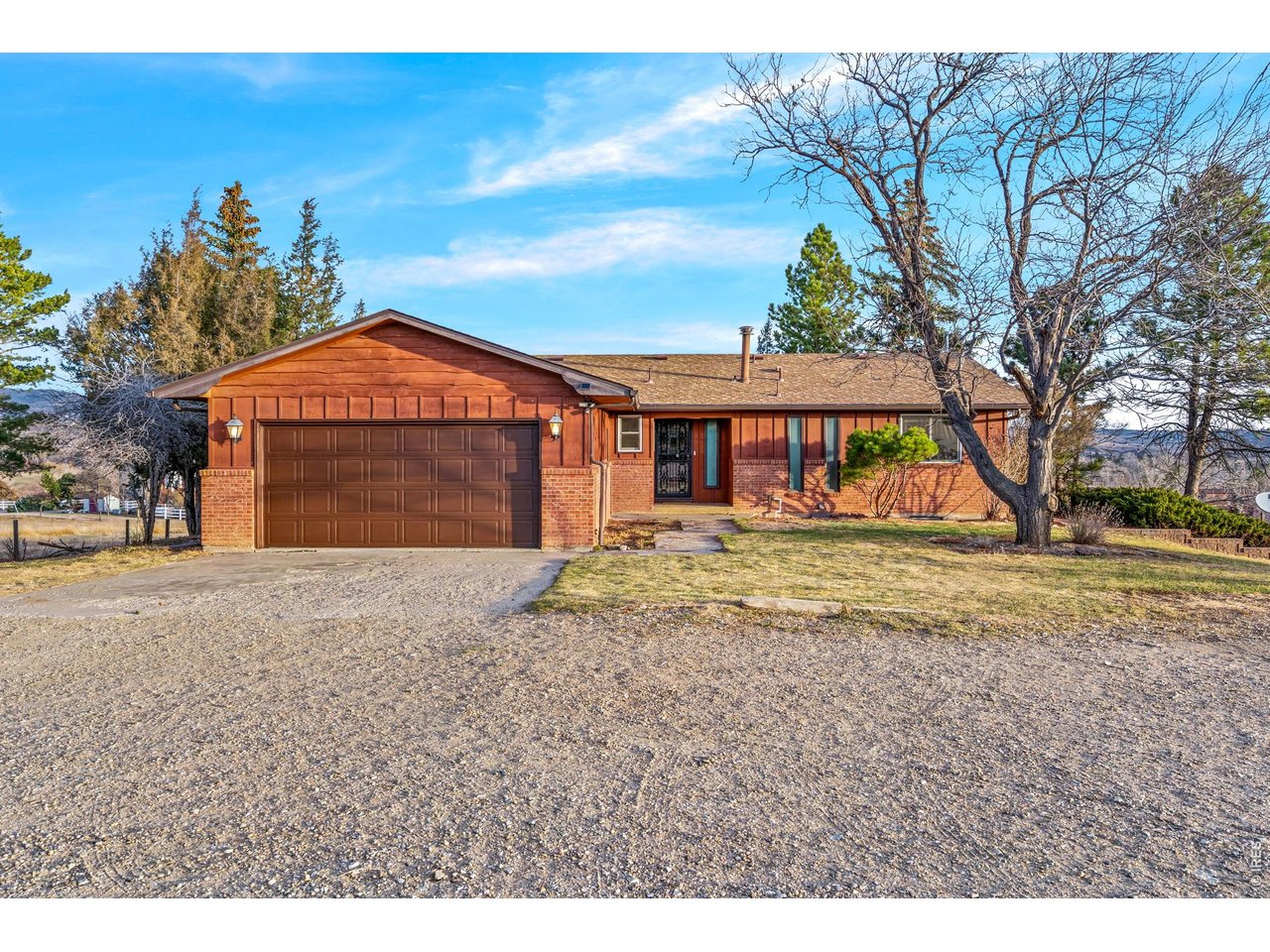 Kittle Real Estate presents, set on nearly ten acres, this custom brick ranch frames the Foothills and Devils Backbone as your everyday backdrop, creating a setting that feels private, peaceful, and incredibly scenic from every angle of the property. Bright, well-defined living zones give this home a natural flow while still offering a sense of separation where it counts, making each space feel purposeful, comfortable, and easy to use day in and day out. The spacious living and dining area is anchored by a striking stone fireplace, creating a warm focal point, while sliding door access to the wraparound deck keeps the connection to the outdoors front and center. The kitchen offers ample prep space, generous storage, and room to add a breakfast nook or rolling island, all while flowing seamlessly into the sunroom for added light and versatility. Just off the kitchen, this light-filled space creates the perfect spot to relax, recharge, or enjoy the surrounding views in a more sheltered, year-round setting. Two main-level bedrooms each feature dual closets, while the primary suite includes its own ensuite bathroom for added convenience. Downstairs, the massive walkout basement offers endless room for recreation, hobbies, or additional living space, complete with a second brick fireplace and two more bedrooms that add flexibility for hobbies, guests, or multi-generational living. The wraparound deck captures sweeping mountain and acreage views, while the concrete patio creates a dedicated space for lounging, entertaining, or simply enjoying the quiet surroundings. The property is also set up for equestrian use or other outdoor pursuits with a loafing shed and pasture already in place, giving you the freedom to make the most of the land. Just minutes from Boedecker Lake for even more outdoor recreation, with easy access to shopping and dining.