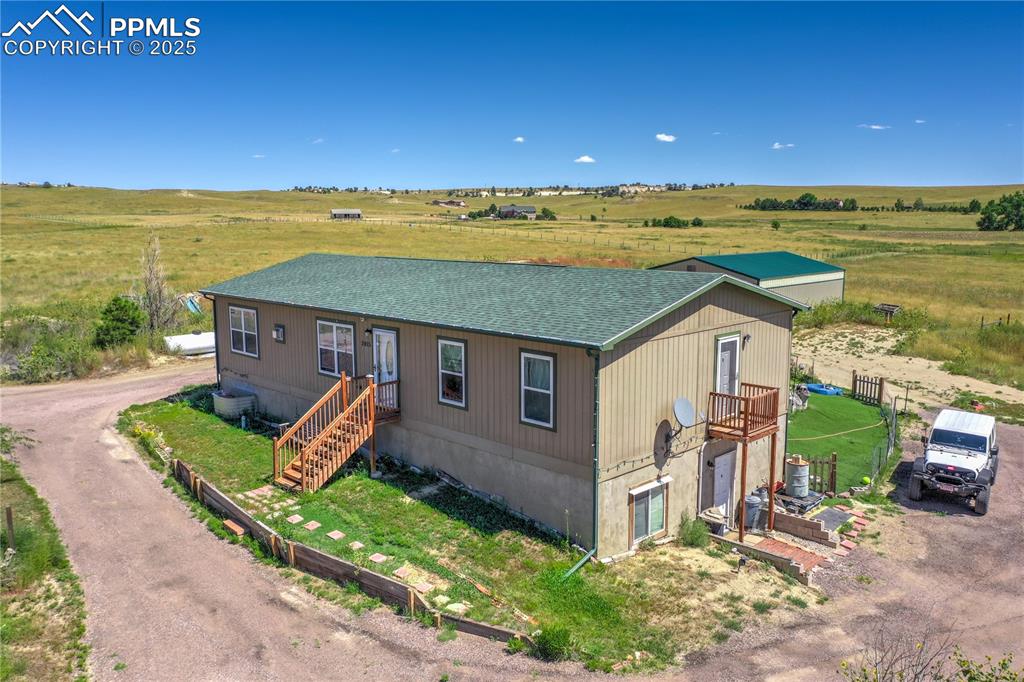 COME AND SEE this exceptional 40+ acre Colorado horse property offering wide-open spaces, mountain views, and true country living with NO HOA. Built in 2015, this spacious 2-story single-family home delivers the perfect blend of comfort, functionality, and privacy—ideal for anyone seeking a homestead, hobby farm, or rural retreat on Colorado’s peaceful eastern plains.The main level features an inviting open concept living room, a gourmet kitchen with modern finishes, and a dining area with walkout access to the backyard. You’ll also find two main-floor bedrooms with a shared full bath, plus a convenient main-level laundry room with its own south-facing mini deck. The main-floor primary suite includes a large walk-in closet and a ¾ bath with dual vanities—perfect for those wanting easy main-level living.The partially finished walk-out basement offers endless potential: two non-conforming bedrooms (just add closets!), a third bathroom, a large game/bonus room, a cozy flex space, and a family room with direct access to the driveway. An extra-long under-stair storage area adds even more functionality.Outside, this property is a dream for anyone needing space for animals, equipment, or agricultural use. The massive solar-powered pole barn/workshop can support horses, vehicles, RVs, tractors, or large projects. Additional outbuildings near the home provide even more storage options for livestock or tools. The backyard includes a fully fenced in area—great for pets, entertaining, and outdoor living. The acreage extends to the east and south, fully fenced and equipped with a private well, septic system, propane tank, and irrigation, making it ideal for gardening, farming, or future expansion.Enjoy unobstructed Pikes Peak and Front Range mountain views, peaceful surroundings, and the freedom to use your land your way. Properties with this level of versatility and acreage are rare—schedule your private showing and start your Colorado homesteading lifestyle today!