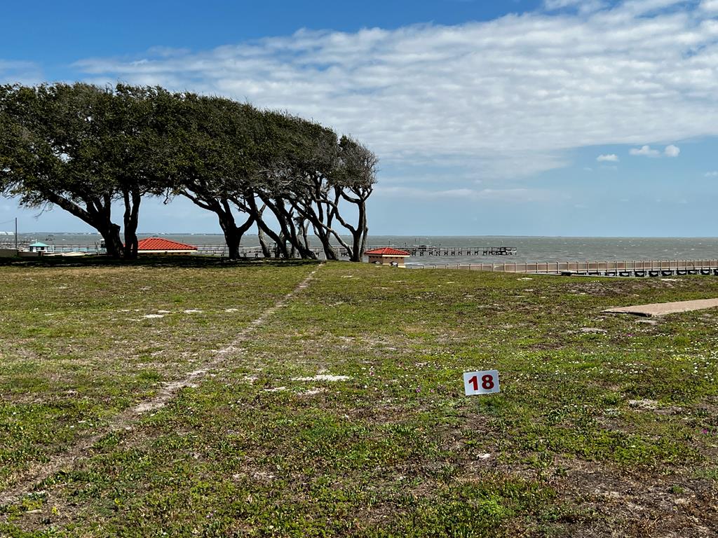 It's time to own your own exclusive inner sanctum in Royal Oaks! Build your custom exceptional waterfront estate on this oversized lot with 180 degree view of Aransas Bay. Wake to the endless sunrises glistening over the Aransas Bay and sweet sounds of the water from this 18,500 sq.ft. lot. Royal Oaks is a world unto itself umbrellaed with enchanted windswept Oak trees, sprinkled with sitting areas, walking trails lit with quaint light posts. The tastefully designed neighborhood is gated with easy access to highway 35 and its main entrance fronting Fulton Beach Rd. The cobble stone entrance with guard house meets with the storybook curved stucco and stone privacy fence lining the front and back of the development providing next level privacy. Molded for prestigious living, you will adore the amenities including the two putting greens, stone gazebo with brick fire pit and lighted pier with fish cleaning station.