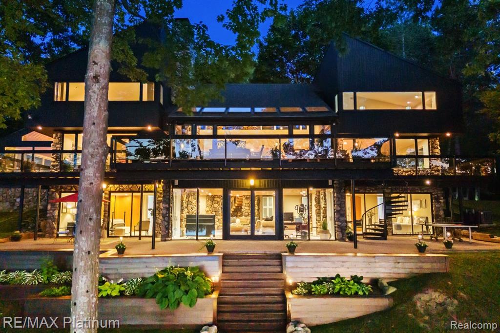 Architectural Masterpiece on Private All-Sports Lake. Welcome to 2095 Brighton Shores Trail, a truly one-of-a-kind estate designed by nationally renowned architect Lou DeRosier. Nestled on over 8 acres with 300 feet of prime frontage on Pardee Lake, this stunning residence blends artistic vision with natural luxury. From the moment you step inside, you’re greeted by sculptural staircases, including a dramatic floating staircase, grand stone fireplaces, and rich natural finishes. Walls of windows bathe the home in sunlight while framing breathtaking lake and wooded views. The custom gourmet kitchen, outfitted with professional-grade stainless steel appliances, is ideal for hosting large gatherings and entertaining in style. The expansive lake level is perfectly suited as an in-law or guest suite, complete with multiple bedrooms and two full baths, including a luxurious walk-in steam shower with multiple shower heads. Enjoy dual staircases for added convenience and accessibility—a serene retreat for overnight guests or extended family. Outdoor living reaches a new level with a cedar-clad boathouse featuring built-in media, creating the ultimate lakeside lounge for fishing, relaxation, or summer movie nights. A separate carriage house outbuilding, already plumbed for a full bath, offers flexible options for a private office, guest quarters, or creative studio. And for an unforgettable experience—watch the infamous Howell Balloon Fest from your boat or your deck, with front-row views over Pardee Lake. Additional highlights include: • Elevator-ready design for future accessibility. • Expansive gathering spaces inside and out. • Potential as a private residence, rehab retreat, or executive getaway. Whether you’re hosting a celebration or seeking solitude on the water, this home offers a rare opportunity to own an architectural jewel in a peaceful, natural setting.