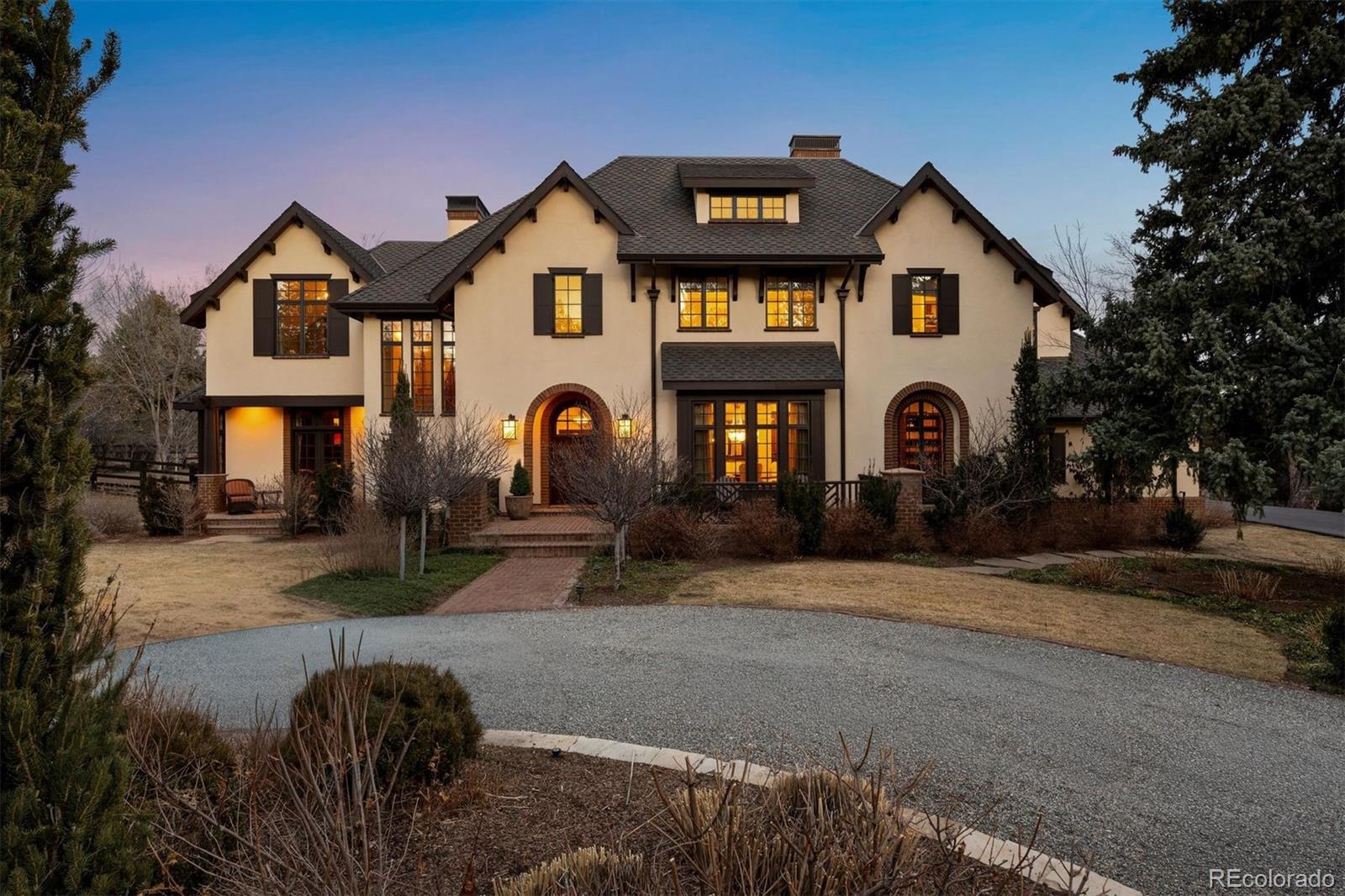 Set on 2.3 acres behind a gated, tree-lined drive in Cherry Hills Village, 4 Vista Road is a rare combination of scale, craftsmanship, and privacy. This custom Craftsman estate by KC Jones is thoughtfully designed for both daily living and entertaining, with impeccably landscaped grounds, terraces, and outdoor living spaces that feel expansive yet intentional.Highlights include a dramatic two-story great room with a 19-foot beamed ceiling, wood-burning fireplace, and accordion doors opening to outdoor entertaining areas, a gourmet kitchen with Sub-Zero and Wolf appliances plus butler’s pantry, a wood paneled library, and main-level office. The primary suite features a beamed ceiling, gas fireplace, sitting area with built-ins and coffee bar, private balcony, five-piece bath, and dual oversized closets.The walkout basement offers flexible living and entertaining spaces, including family room with gas fireplaces, wet bar, media room, craft/art room, wine room, full gym, and two guest bedrooms. The guest house features a family room with fireplace opening to a covered patio, a full kitchen, private bedroom, pool bath, and an upper-level bunk roomOutdoors, the estate provides multiple terraces, pool, spa, hot tub, fire pit, garden beds, dog run, and built-in grill. The finished five-car garage includes storage, bonus office with powder bath, and heated workshop/gear room. Rare acreage, meticulous craftsmanship, and thoughtfully curated spaces make this a premier Cherry Hills Village estate.