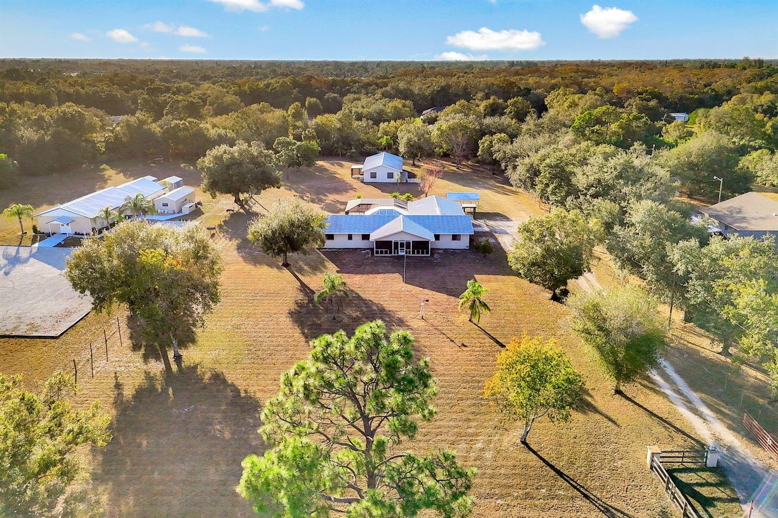 Looking for generational living? This is it! Endless possibilities await on this rare 2.5-acre AG-2 zoned property in North Fort Myers! Fully fenced with a gated entrance, this unique estate offers two separate homes—ideal for multi-generational living, rental income, a home-based business, or equestrian use. The main residence features 4 bedrooms, 3 bathrooms, a screened-in pool with a party-worthy deck and lanai, new appliances, and a 3-car garage with workshop area. The thoughtfully designed layout includes a private 4th bedroom and 3rdbath suite with its own separation—perfect as an in-law suite, teen retreat, guest quarters, or potential income opportunity. Located toward the rear of the property is a second home offering 2 bedrooms, 1 bathroom, a screened porch, and a 1½-car garage, providing excellent flexibility for extended family, visitors, or rental use. With AG-2 zoning, there is ample room for horses, gardens, workshops, or business equipment, all while enjoying the privacy and space of acreage living—yet still conveniently located near shopping, dining, and major roadways. Whether you’re looking for generational living, income potential, or space to live and work, this versatile property delivers a truly rare opportunity in North Fort Myers.