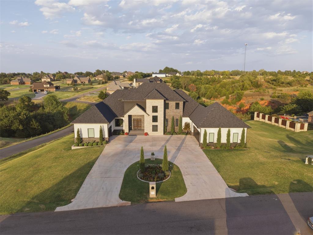 A rare offering in Norman’s gated Manor Lake Hills. This luxury home offers more than 9,000 SF of thoughtfully designed living space on approximately 1.93 acres with direct access to the community pond. Built in 2024 & spanning 3 levels, the home showcases exceptional craftsmanship, technology & attention to detail.The chef’s kitchen features dual oversized islands, custom cabinetry, marble hood & backsplash, built-in JennAir refrigerator/freezer, double ovens, appliance & food pantries & adjoining bar. White oak, custom millwork, imported lighting, mirrors & hardware, motorized shades & integrated audio are featured throughout.The flexible floor plan offers 6 bedrooms, including a private gym, with each bedroom designed as a suite with a full bath & large walk-in closet. The primary retreat features custom built-ins, 2 walk-in closets, steam shower & smart toilet, plus a second primary suite upstairs.The walk-out lower level is built for entertaining with a full second kitchen, game/gathering spaces, gym & professional home theater featuring 22 speakers, 2 subwoofers, 120" screen, Sony projector & reclining theater seating.Outdoor living includes a balcony overlooking the pond, covered patio with gas/wood-burning fireplace & direct pond access. A dock has been ordered for installation, creating a place to fish & enjoy the water. Seller is open to offering a pool & backyard oasis package. PS. You have access to the neighborhood clubhouse pool and walking trails! Additional features include 2x6 construction, spray foam insulation, 4-zone HVAC, 600-amp service, 2 tankless water heaters, whole-home dehumidification, central vacuum, Sonos/Sonance audio & EV charging.