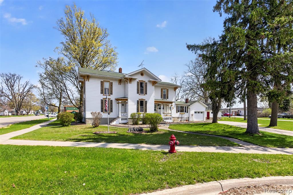 5+ Acres Total, Including Private Lake Acreage.  Step back in time with this charming 5-bedroom, 1.5-bath Vintage Victorian full of character, warmth, and timeless detail! From the inviting front entry with a beautiful curved staircase to the spacious living room, this home showcases classic charm with tall ceilings, rich wood flooring, detailed trim, and plenty of natural light throughout. The kitchen offers a unique blend of vintage appeal and function with wood accents, island workspace, and an open feel to the dining area. Enjoy the bright enclosed porch/sunroom overlooking the yard, perfect for relaxing, entertaining, or morning coffee. Outside you’ll find a rare setting with views and access near the water, a nice yard, and a garage with great storage/workshop potential. Loaded with charm, space, and history—this one is a must see!