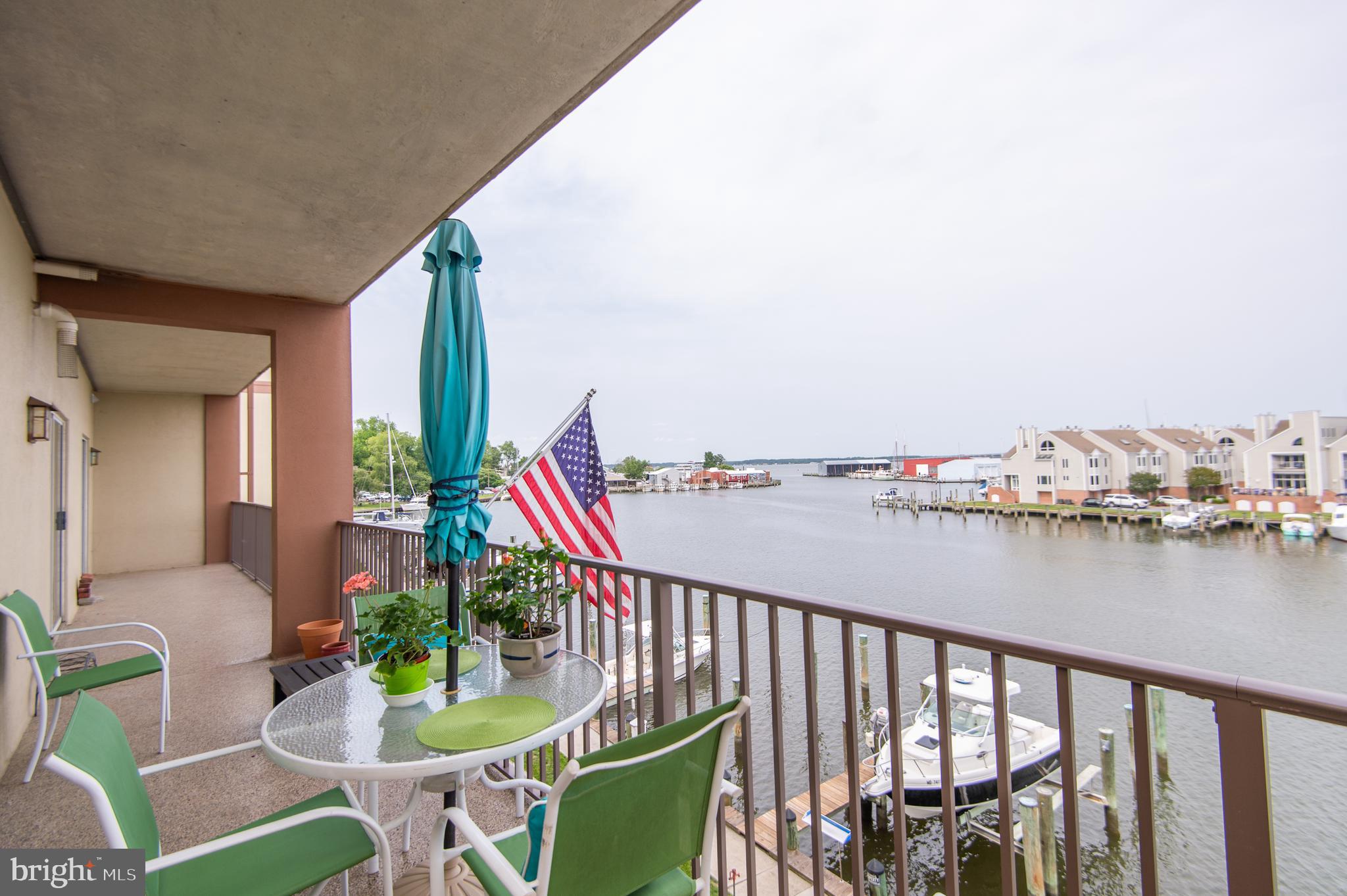 Wake up to shimmering views of Cambridge Creek and laid-back living in this beautiful waterfront condo. This light-filled 2-bedroom, 2-bath home offers a spacious open-concept layout, ideal for both relaxing and entertaining. The kitchen features updated cabinets with soft-close drawers and slide-out shelves, spacious countertops, a built-in microwave, dishwasher, stove, and refrigerator with water dispenser/ice maker. The open countertop area has breakfast bar seating for two. In addition to the cabinet storage, the kitchen has two roomy pantry/closets with shelves. The 48-foot-wide balcony runs the entire width of the condo and is accessible from the living room and from both bedrooms! It’s the perfect spot to sip morning coffee or unwind at sunset while watching boats glide by. The primary suite features a walk-in closet and an en-suite bath with a walk-in shower. The second bedroom is only slightly smaller than the primary. The property features a hall bath, a laundry room, and an open-plan living room and dining area. The unit has been updated with recessed lighting and bamboo flooring in most rooms and a dark cherry hardwood in the primary bedroom.  All four sets of sliding doors to the balcony feature Hunter-Douglas vertical cellular shades. The primary BR shades are room-darkening, creating a restful sanctuary. Additional features include a 7 x 16 secure storage room across the hall from the unit, secure parking with one assigned spot and additional parking in front of the building. Building entry is secure with an access code required. A deeded boat slip is included in the purchase price, allowing you to explore the Choptank River and the Chesapeake Bay. This property is an easy walk to downtown restaurants and shops. What are you waiting for? This could be yours in time to enjoy the summer!