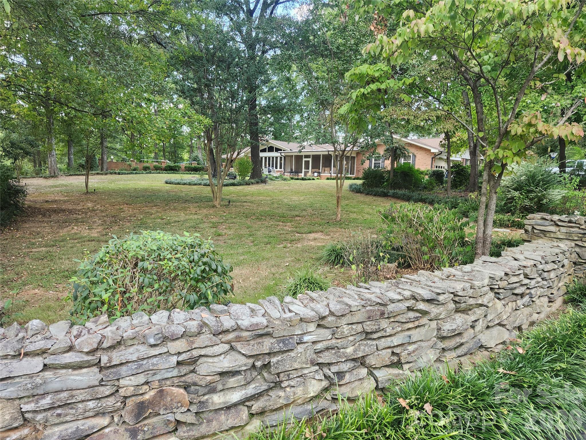 Welcome to your own private retreat! Tucked away on approximately five beautifully wooded acres, this charming brick home offers privacy, comfort, timeless appeal and a wonderful setting for everyday living and entertaining. This home features three spacious bedrooms, three full baths & 2 half baths. A jack & jill bath share a shower. The paved circular drive offers an elegant arrival and ample parking.  A standout feature is the bakery, offering a unique opportunity for a dedicated baking space, home-based business or creative culinary retreat. Outside, enjoy the best of country style living with a sparkling in-ground saltwater pool, perfect for relaxing and entertaining during warm summer days. A screened back porch, concrete patio, brick patio and welcoming front porch only add to this enchanting property.