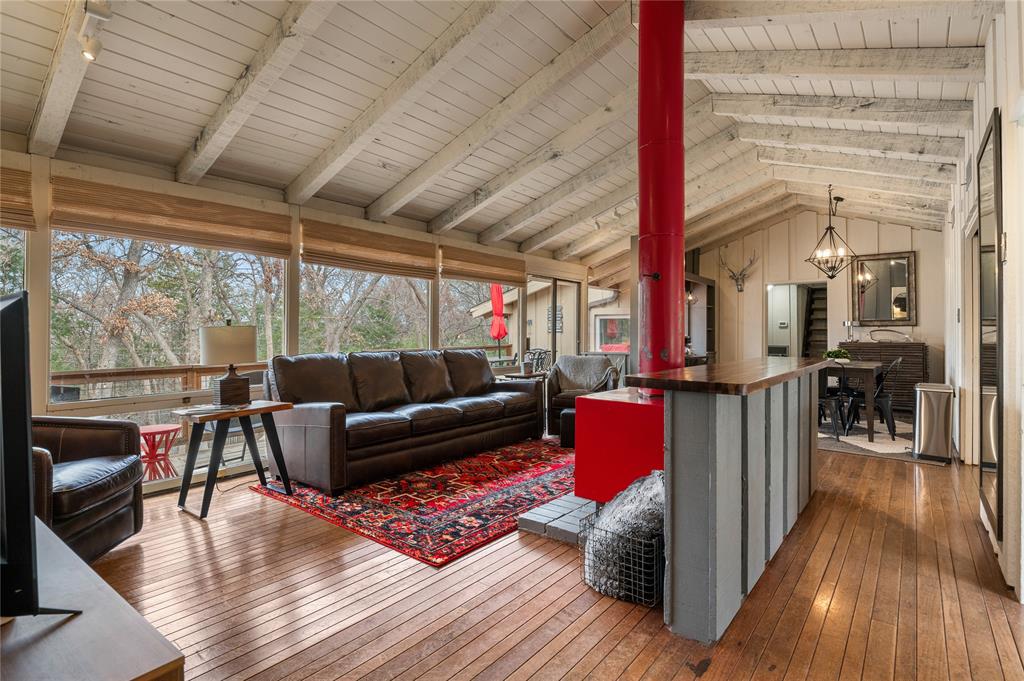 Own a little piece of heaven near Lake Texoma in the exclusive Tanglewood community! This charming rustic cabin is just minutes from the lake, Tanglewood Resort, and Highport Marina, offering the perfect blend of relaxation and recreation. Step inside to soaring vaulted beamed ceilings, distressed wood floors, and a stunning wood-burning fireplace that anchors the light-filled open-concept living and dining area. A wall of windows overlooks the heavily treed, fully fenced backyard, creating a peaceful retreat surrounded by nature.The spacious primary suite features an ensuite bath, while the secondary bedrooms provide comfortable accommodations, including one with its own private bath. A loft area offers additional sleeping space, a reading nook, or a flexible bonus area to fit your needs.Designed for both entertaining and unwinding, the property includes a separate game room & expansive outdoor living spaces. Gather around the oversized fire pit, enjoy the sprawling back deck, or spend evenings under the stars in the privacy of your wooded backyard! Whether you're launching from nearby Highport Marina for a day on Lake Texoma, enjoying the amenities of Tanglewood, or simply escaping the hustle and bustle of everyday life, this inviting cabin offers the perfect North Texas getaway. Experience the beauty, tranquility, and charm of one of Texoma's most desirable communities. Make this special property yours today!This property also includes parking space for a boat along with a full size utility room.