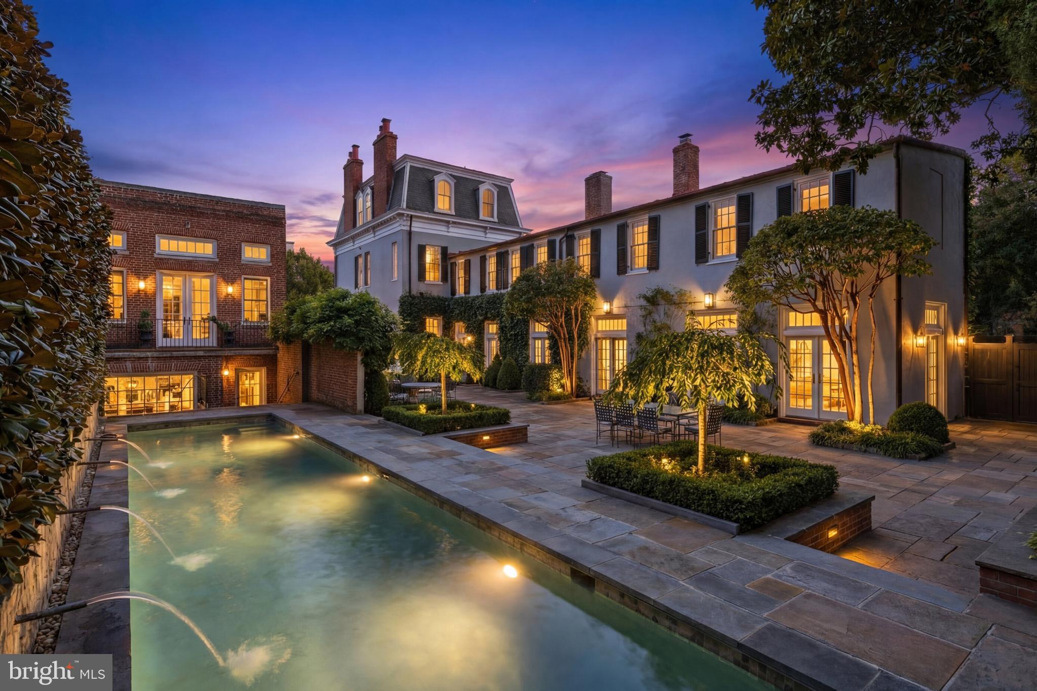 Set along one of Georgetown’s most established residential blocks, 3117–3121 O Street NW presents a rare townhome compound offering exceptional scale, privacy, and versatility. Originally built in 1900 and comprehensively remodeled in 2019, the property encompasses approximately 7,200 square feet across a primary residence and a fully integrated guest house.The main residence honors classic Georgetown architecture while delivering a highly livable, thoughtfully modernized layout. Formal living and dining rooms anchor the main level, each defined by fireplaces and gracious proportions. The kitchen opens directly to the central courtyard through French doors, creating a seamless flow between interior and exterior spaces. Designed for both everyday living and entertaining, the kitchen is outfitted with Wolf and Sub-Zero appliances, multiple refrigeration zones, dual wine storage, and a breakfast area with its own fireplace.Outdoor living is a defining feature of the property. The private, landscaped courtyard is centered around a lap pool with an automatic cover and is complemented by fountains, flagstone patios, and an outdoor kitchen, forming a tranquil retreat rarely found in the heart of the city.The upper levels of the main house are anchored by a dedicated primary suite wing featuring dual walk-in closets and a spa-style bath with a skylight, soaking tub, and dual water closets. Additional bedrooms span the upper floors, many with fireplaces, offering flexibility for guest accommodations, home offices, or private studies. The lower level is equally well-considered and includes a recreation room, gym, theater with seating for eight, and a laundry room.The guest house, accessible both internally through the lower level and via a separate exterior entrance, adds a meaningful layer of adaptability. With its own living space, kitchenette, bedrooms, bathrooms, and direct garage access, it functions seamlessly as guest quarters, extended family accommodations, or a private work-from-home residence. A two-car attached garage with EV charging, along with additional driveway parking, further distinguishes the offering and provides a level of convenience seldom found in Georgetown.Throughout the home, systems and infrastructure have been carefully curated, including multi-zone HVAC, whole-house audio, automated blinds, integrated home automation, and security systems.Defined by scale, outdoor living, and flexibility, 3117–3121 O Street NW represents a rare opportunity to own a timeless Georgetown compound designed for modern city living.
