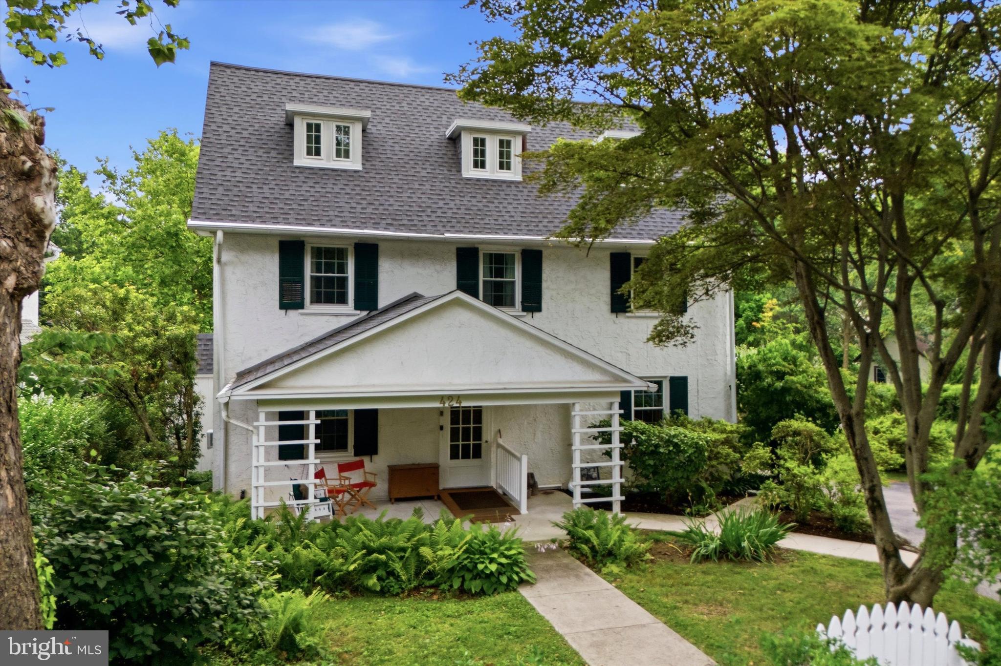 Situated on an extra-wide lot in the heart of Narberth, 424 Haverford Avenue seamlessly blends timeless character with thoughtful updates, offering exceptional indoor and outdoor living in one of Lower Merion Township's most sought-after neighborhoods!A welcoming front porch leads into the center hall foyer, complete with a convenient coat closet and beautiful hardwood floors that continue throughout the home. Glass French doors open to the spacious living room, highlighted by a classic wood-burning brick fireplace and the added convenience of a full bathroom with a walk-in shower. The formal dining room features a charming bay window and ceiling fan, creating the perfect setting for everyday meals or entertaining. Just beyond, a conveniently located powder room leads to the well laid out kitchen, thoughtfully designed with a center island and sink, stainless steel refrigerator, gas range, stainless steel dishwasher, dedicated eat-in area, and a built-in office/desk space ideal for working from home or managing daily tasks.Step outside to the rear deck overlooking a private backyard oasis complete with a swimming pool, beautifully landscaped gardens, and generous yard space—perfect for relaxing, entertaining, or enjoying warm summer days.The second floor offers a spacious primary bedroom featuring a wood-burning brick fireplace and two closets. An adjoining bedroom with custom shelving provides flexibility as a nursery, home office, or dressing room. An additional bedroom with painted wood floors and a large closet, a generous hall linen closet, and a full hall bathroom with a tub/shower combination complete this level.The third floor adds even more versatility with two additional bedrooms, including one with a convenient laundry area tucked into the dormer, along with another full hall bathroom featuring a tub/shower combination.The unfinished basement offers abundant storage space and includes an exterior access door for added convenience. Additional improvements in the home include a newer roof (less than five years old), replacement windows, and a newer sewer line, providing peace of mind for years to come.Enjoy the best of Narberth living, within walking distance from restaurants, shopping, parks, the SEPTA train station, and all the amenities that make this vibrant community so desirable. This is a rare opportunity to own a character-filled home with generous living space, exceptional outdoor amenities, and an unbeatable location in award-winning Lower Merion Township.
